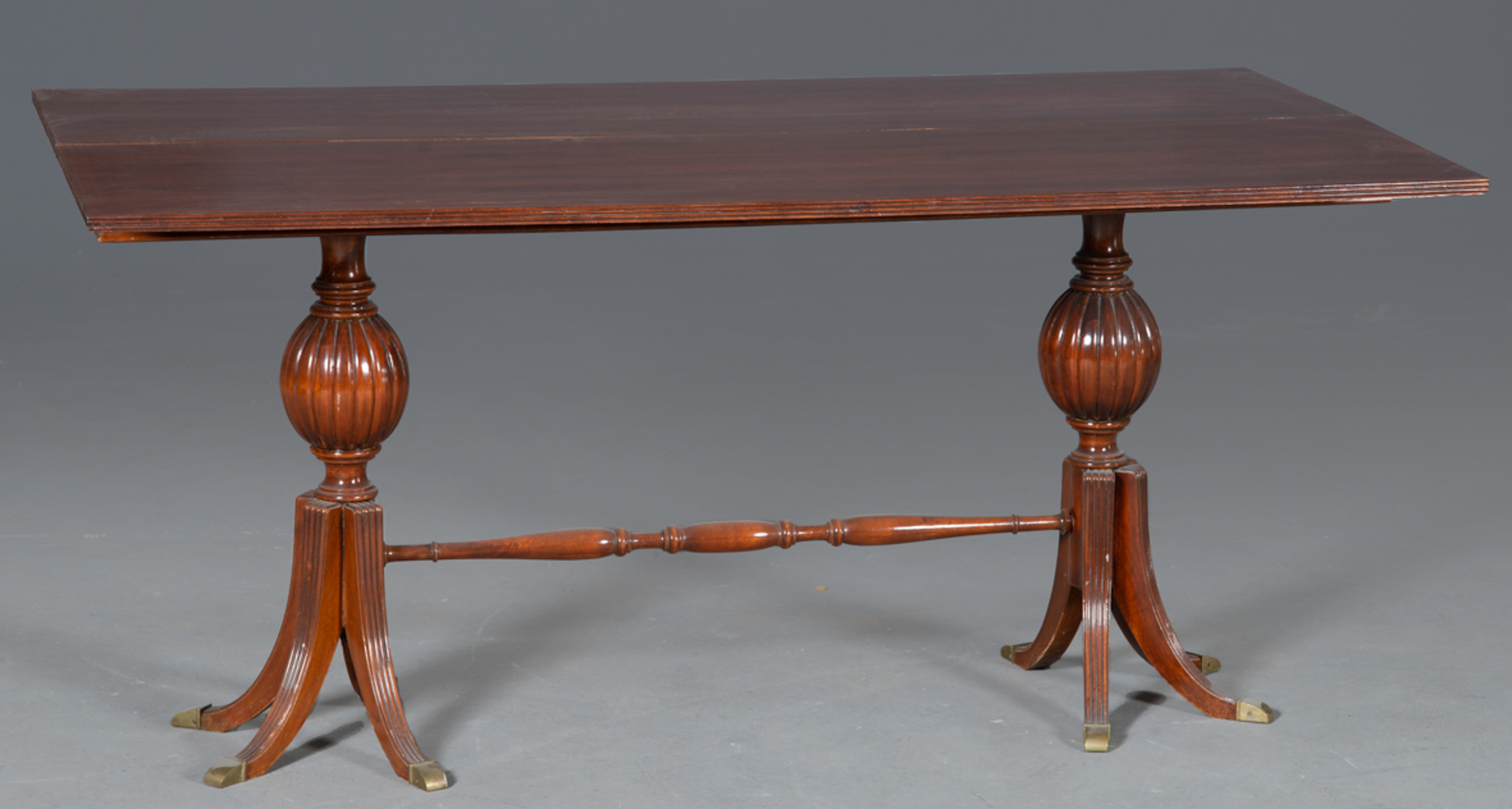 Mesa de comedor en madera tallada sobre doble pata de jarrón unida por travesaño. Tapa plegable....