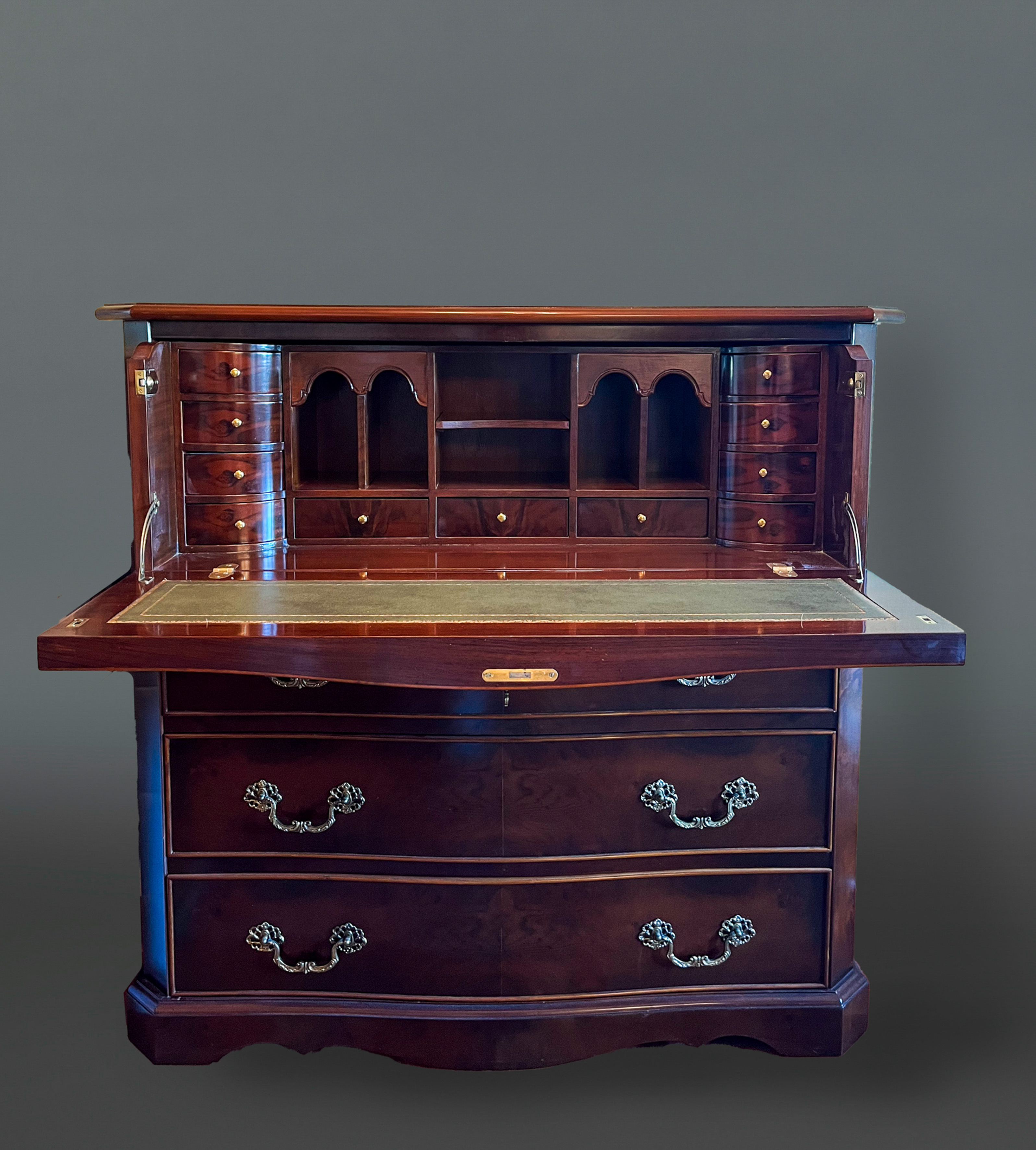 Cómoda escritorio de madera con tres registros de cajones, tapa superior abatible que muestra un...