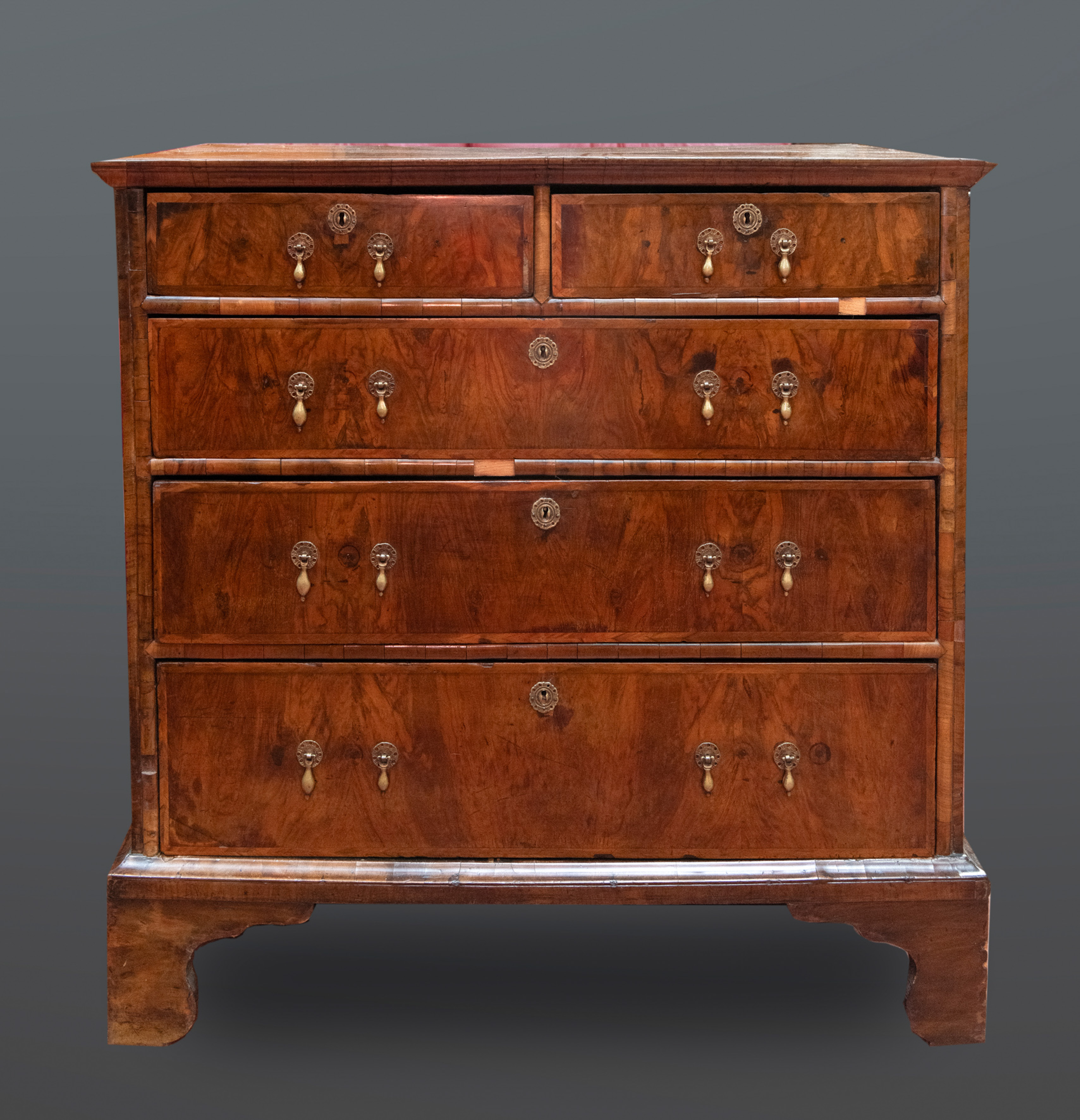 Chest of drawers, ca. 1800. Cómoda William and Mary en madera de raíz de nogal. Compuesta por cinco...