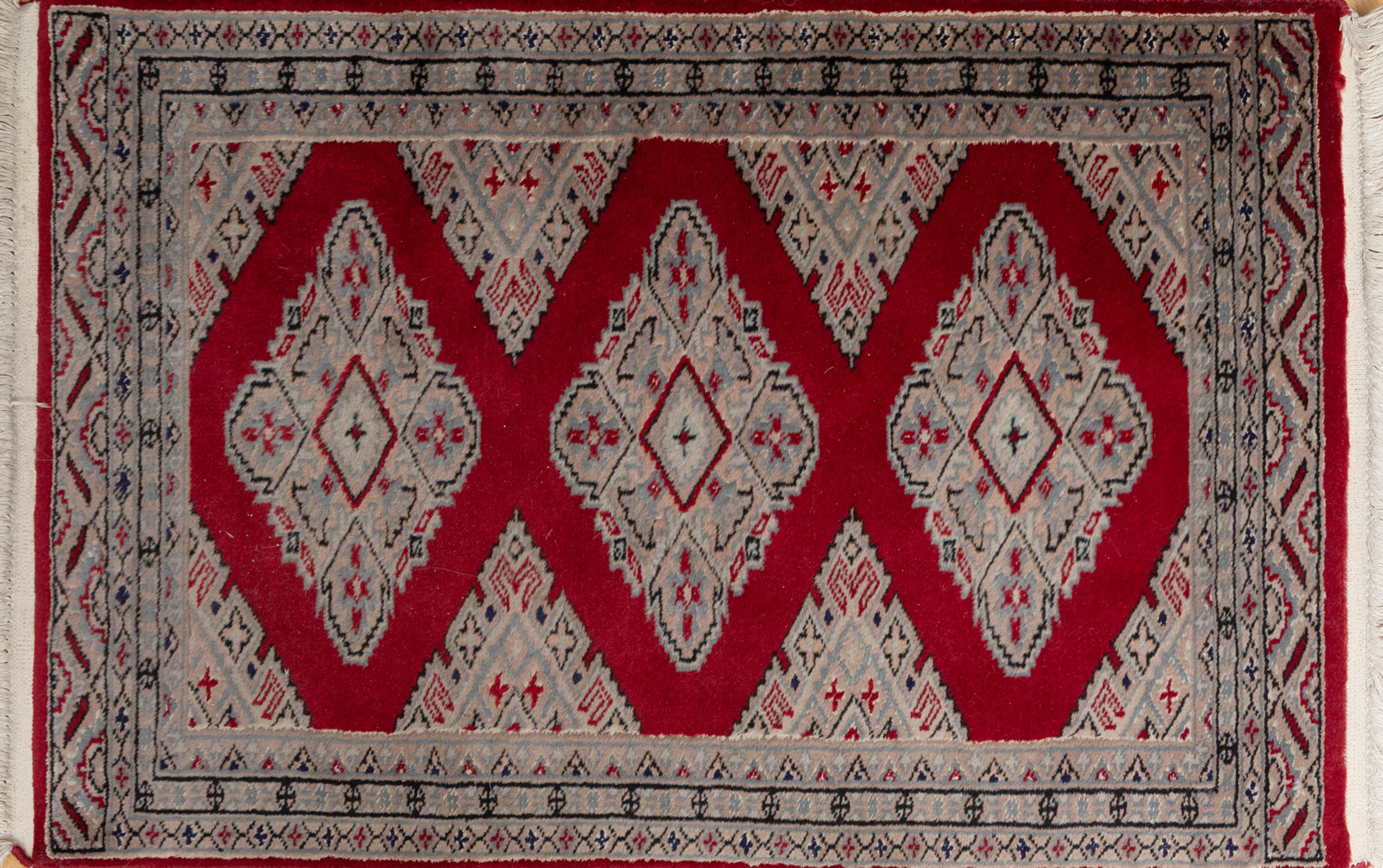 Alfombra de oración persa en lana tejida a mano. De campo rojo con profusa decoración geométrica y...