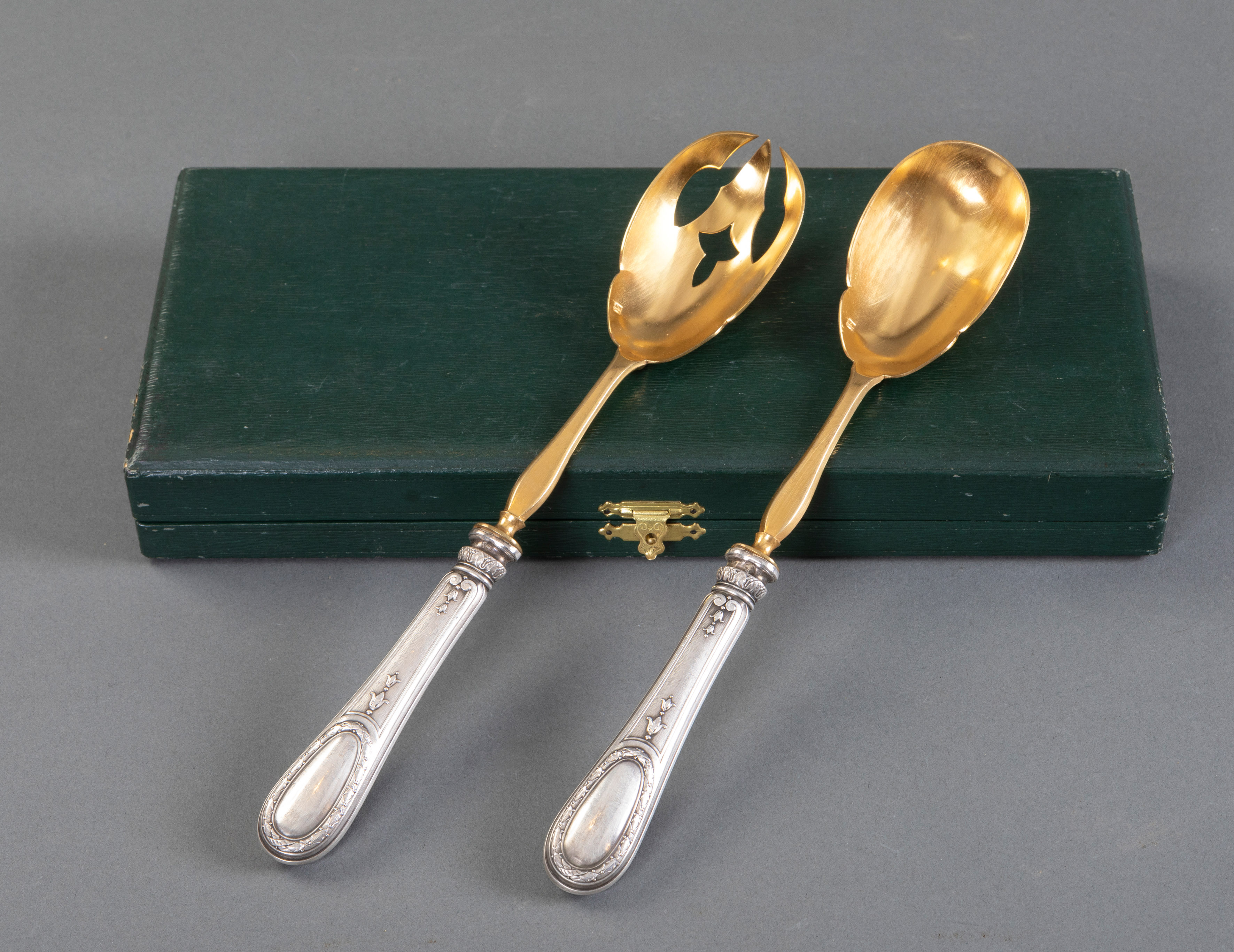 Lote compuesto por dos cubiertos de servir en metal dorado con mango de plata y cuchillo y tenedor...