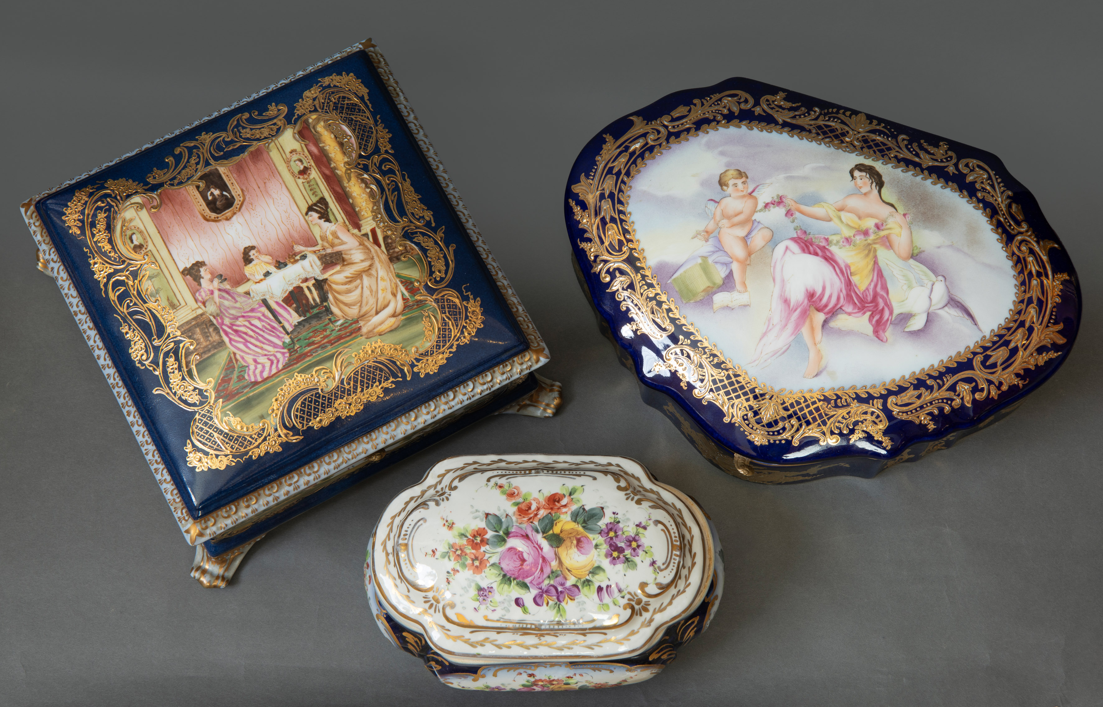 Lote formado por tres cajas en porcelana esmaltada en azul cobalto con escenas galantes en...