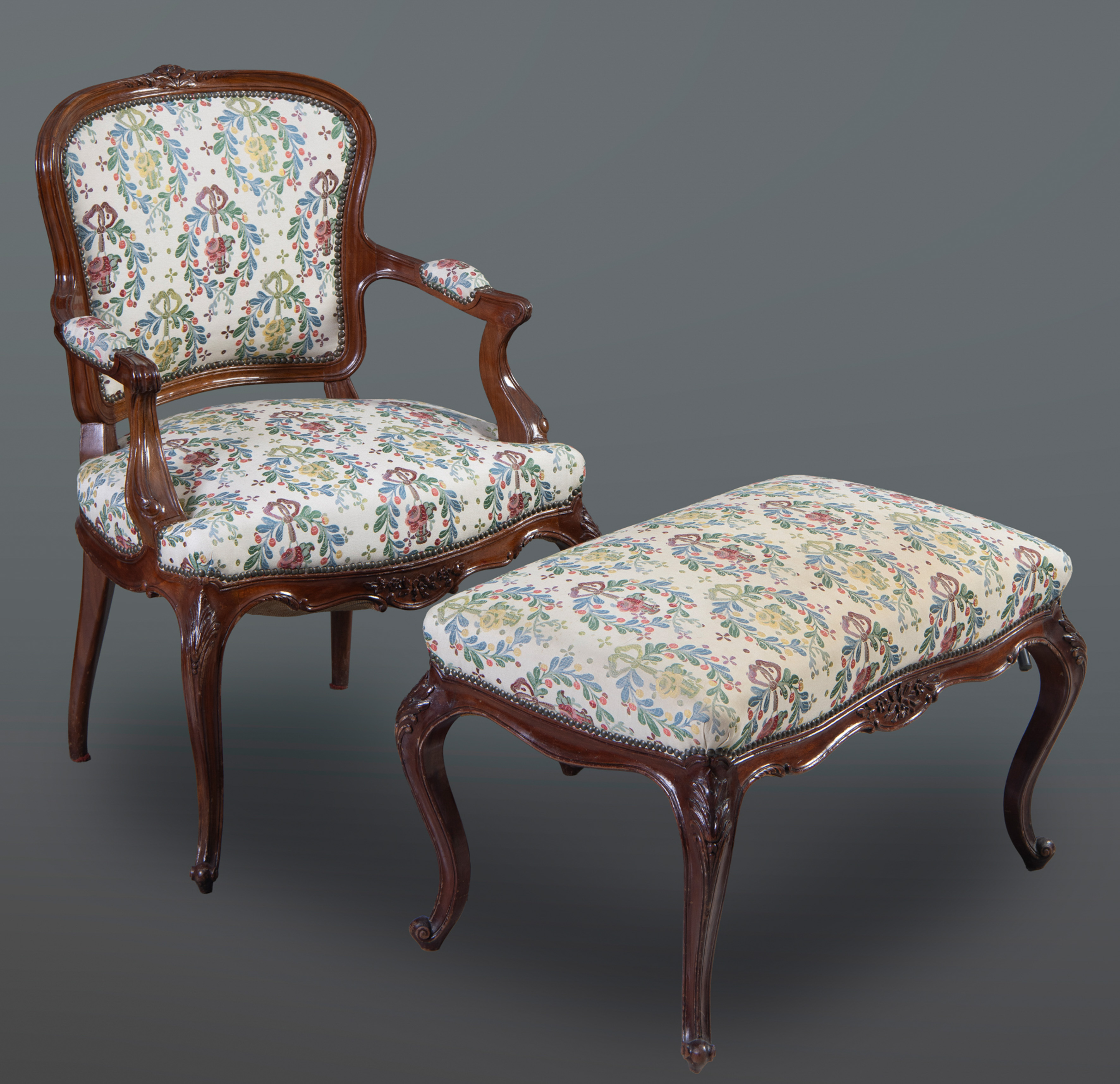 Conjunto de sillón y banco estilo Luis XV
En madera de nogal con remate de flores en copete,...