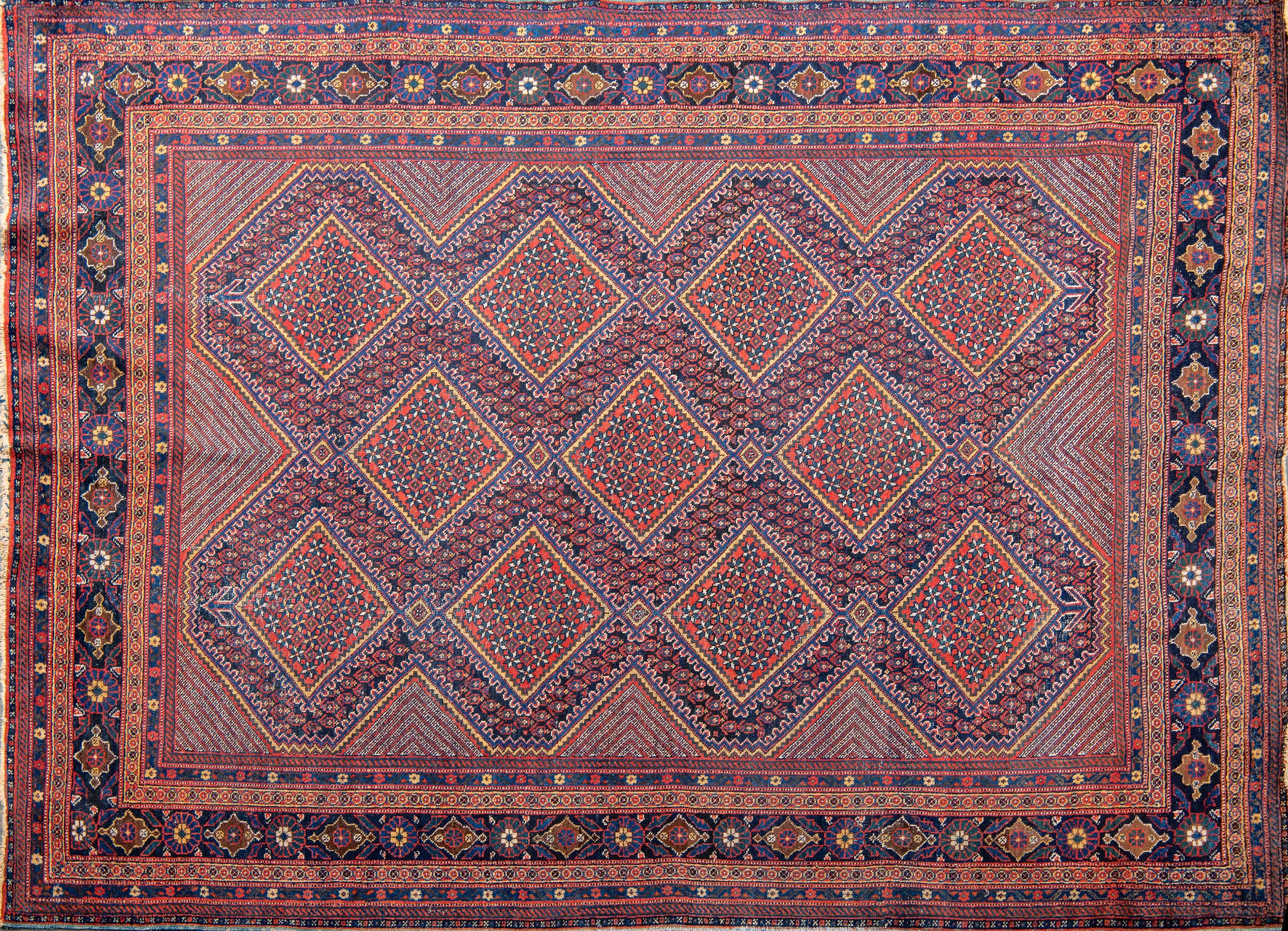 Alfombra turca con decoración de motivos boteh y geométricos en tonos azules, salmón y amarilo....