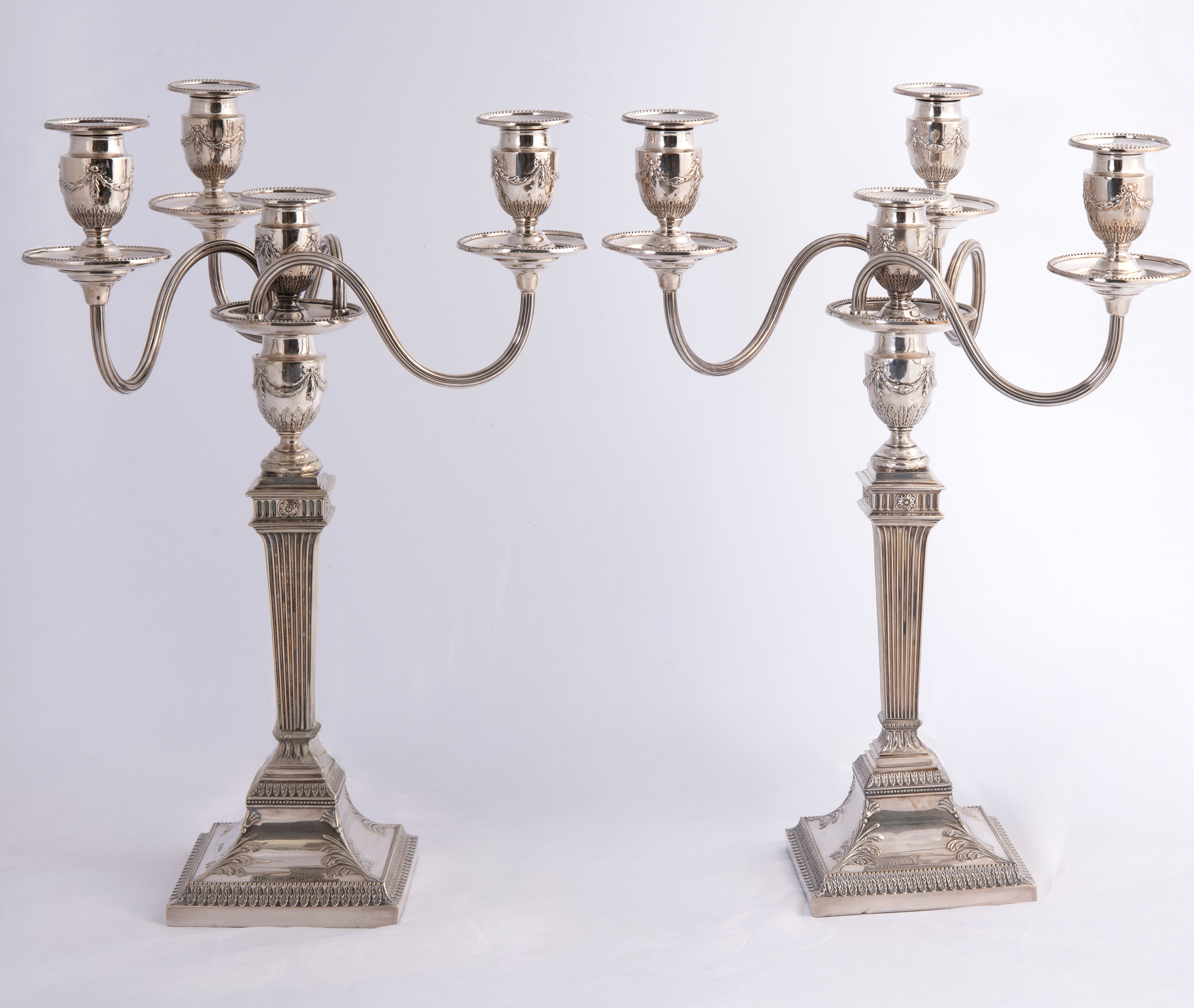 Pareja de candelabros ingleses de cuatro luces. Fuste de columna acanalada sobre pedestal...