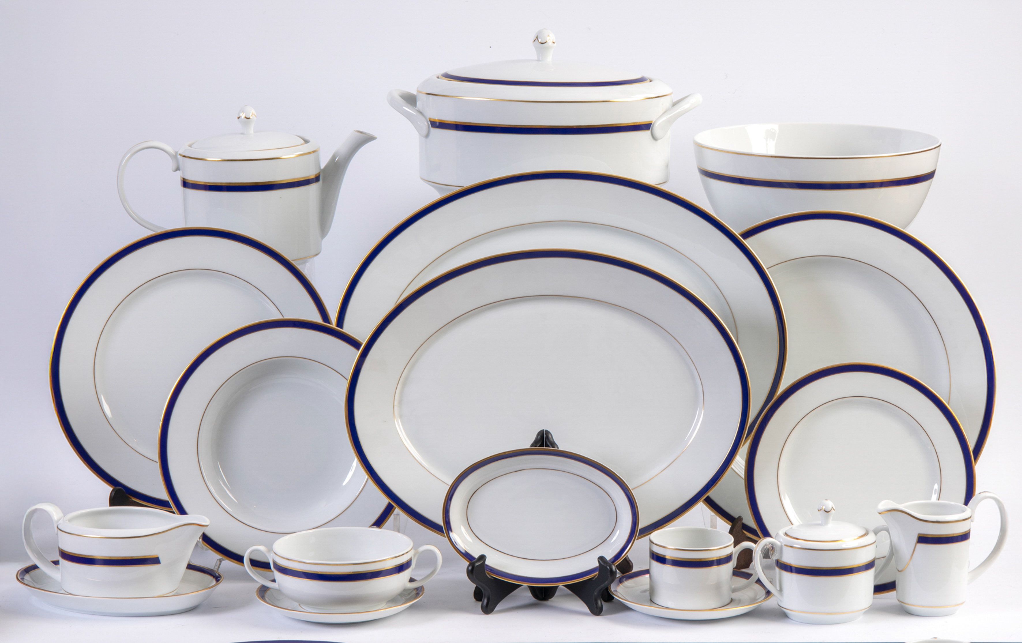 Vajilla en porcelana esmaltada con decoración en cobalto y oro sobre fondo blanc