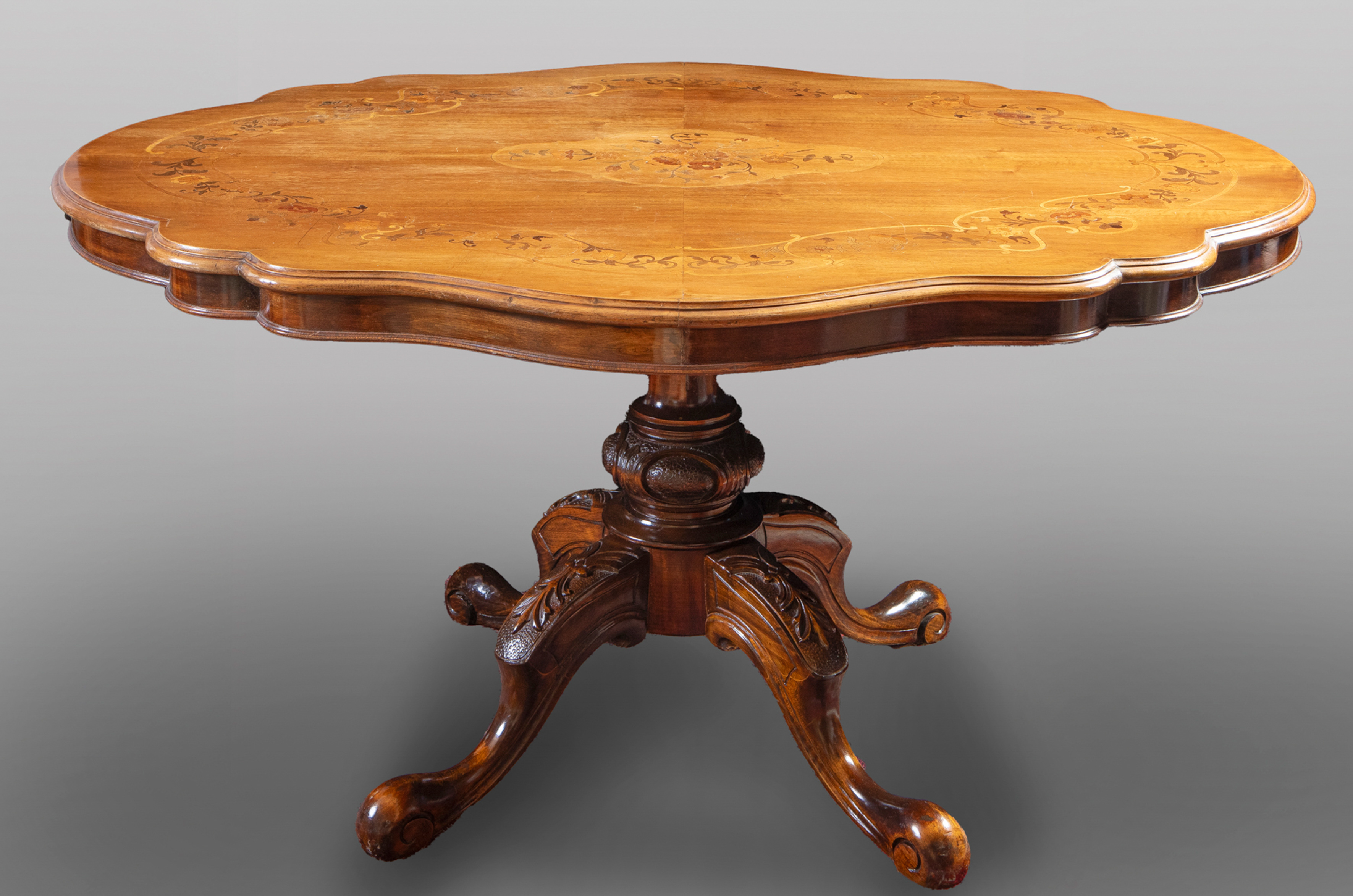 Mesa de centro ppios. de siglo en madera de roble con la tapa ondulada y decorada con guirnalda de...