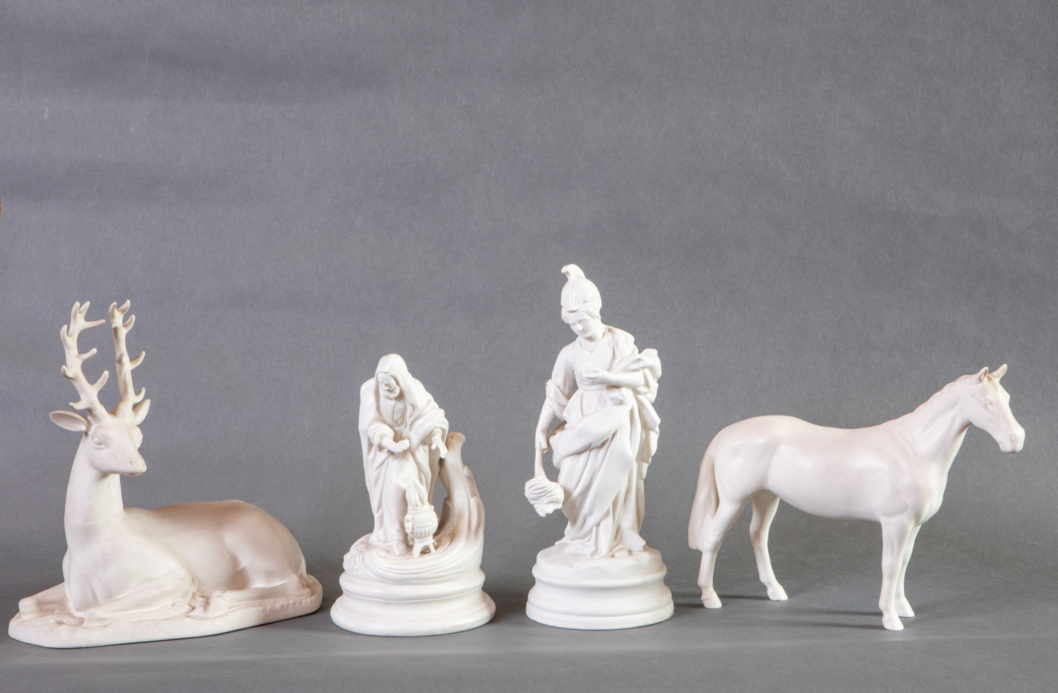 Lote en porcelana de biscuit compuesto por cuatro figuras, dos de animales, un ciervo y un caballo,...