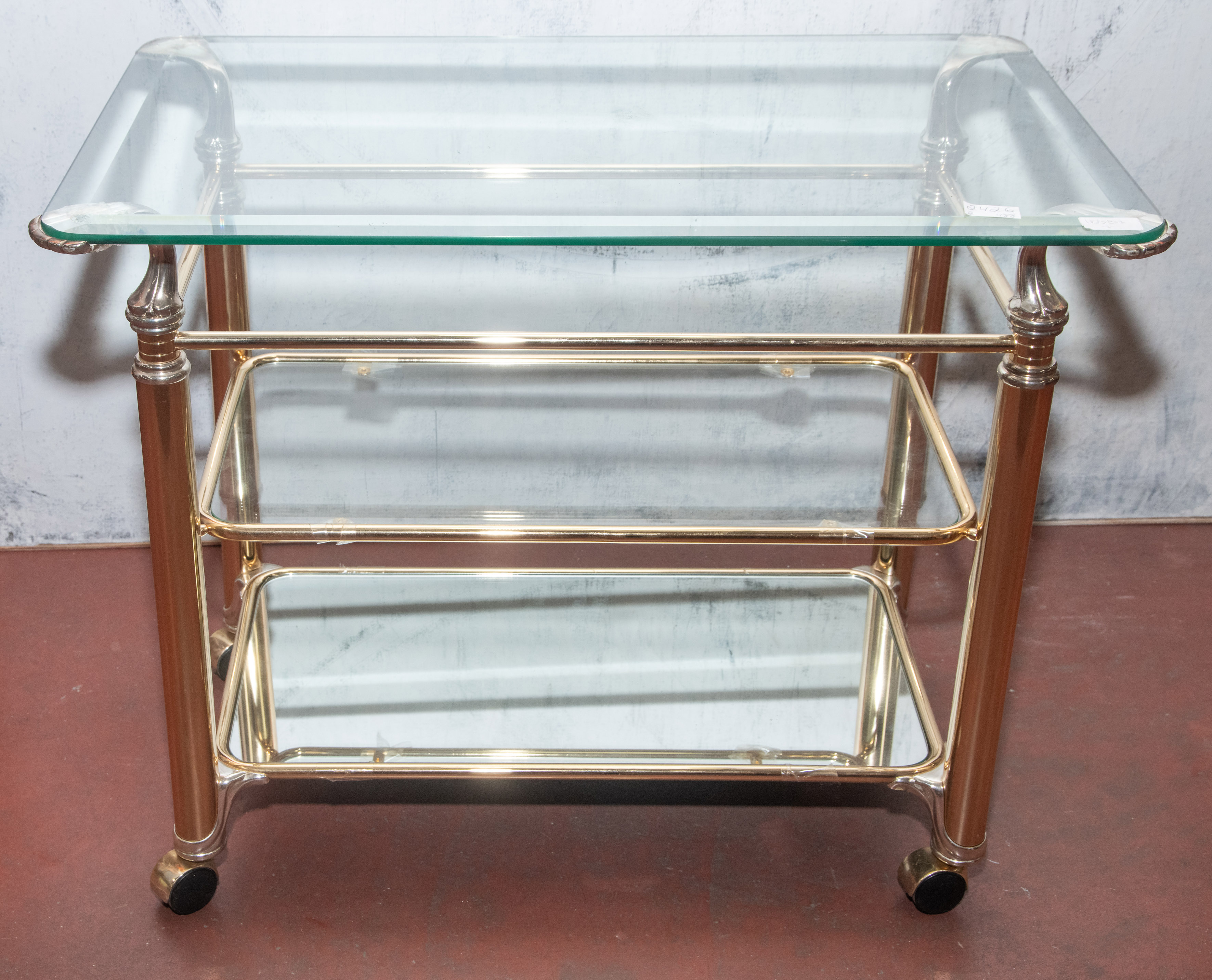 Carrito en cristal y metal cromado con dos bandejas y ruedas. 
Medidas: 64 x 50 x 80 cm.