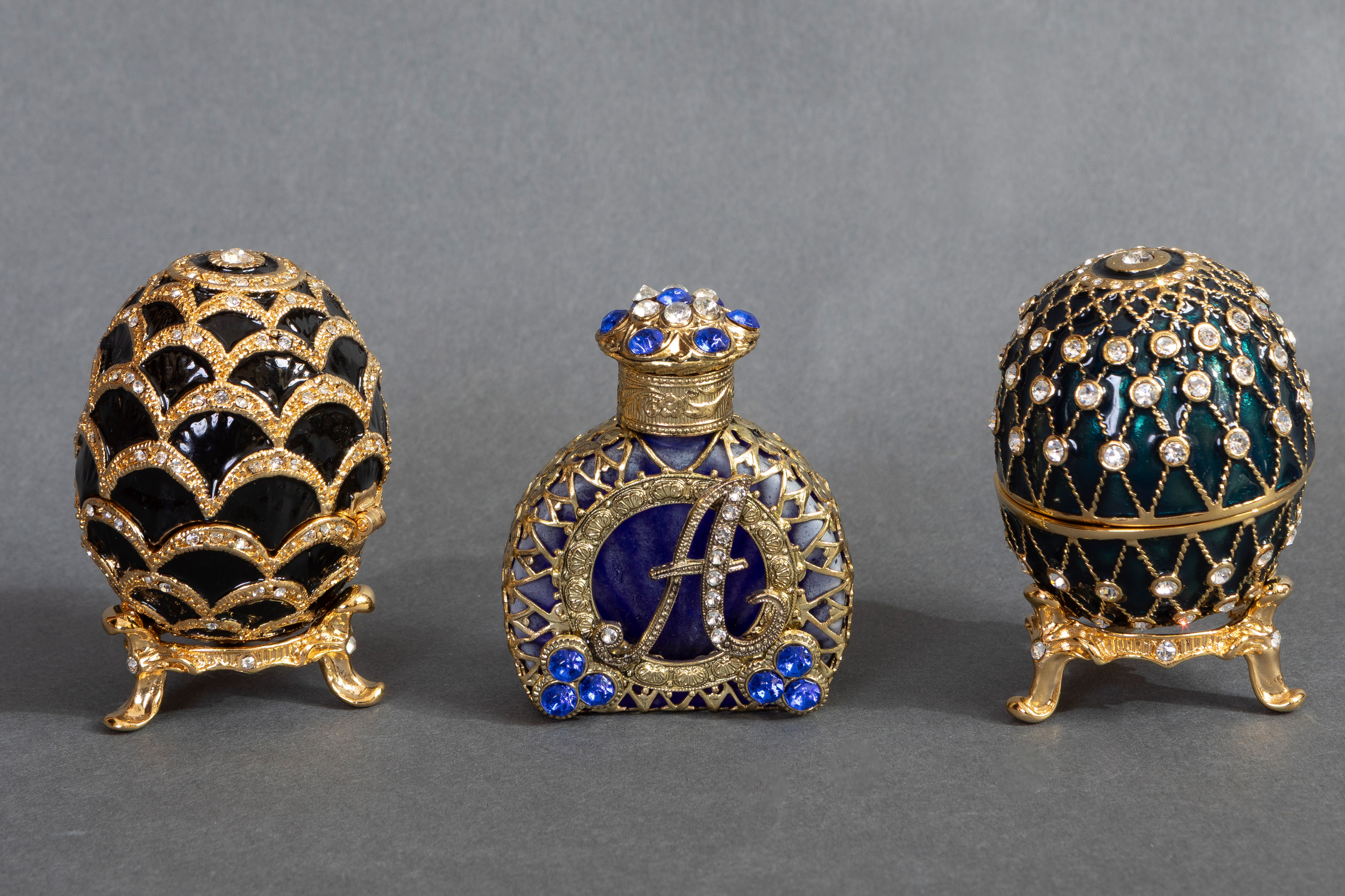Lote compuesto por dos huevos estilo Fabergé, en metal esmaltado en negro con aplicaciones...