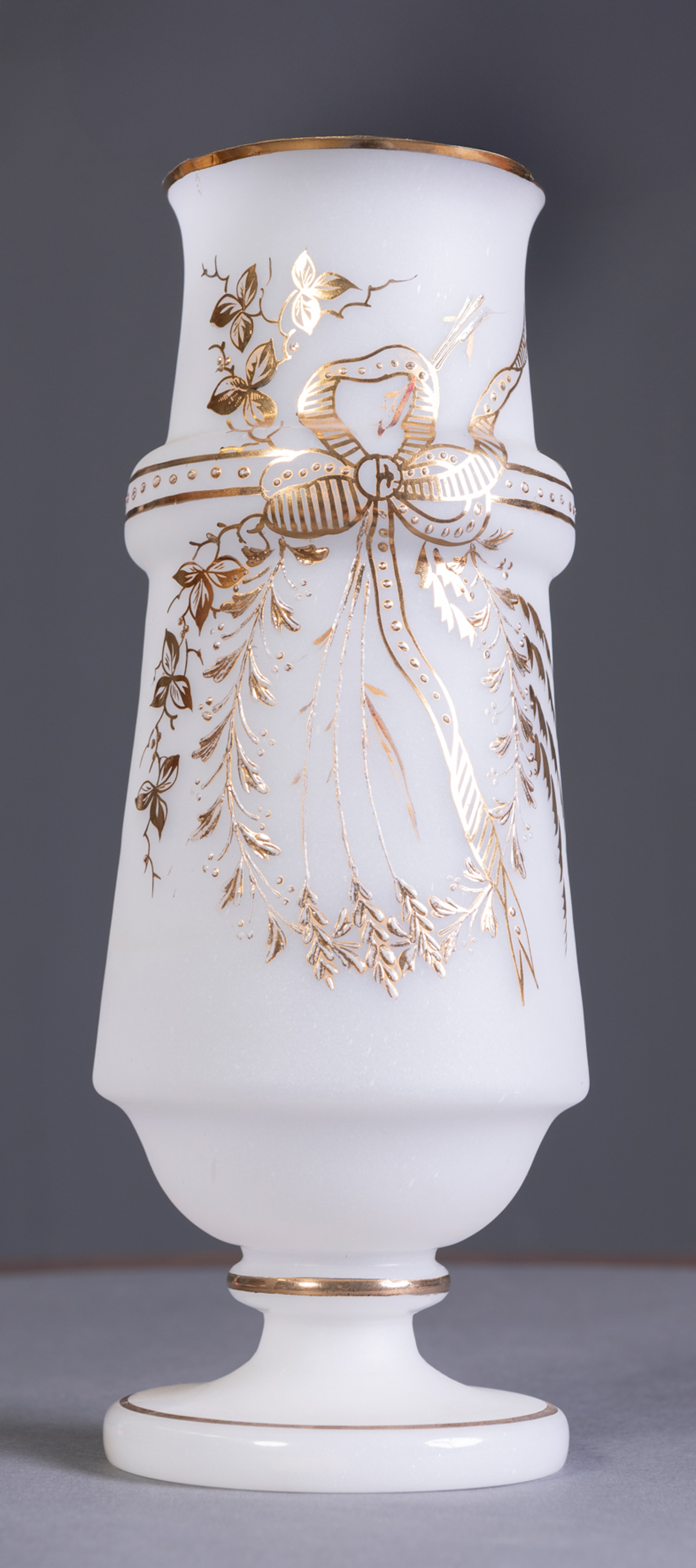Jarrón en opalina con decoración de lazo y guirnalda en dorado, España, S. XIX
Medidas: 32 cm.