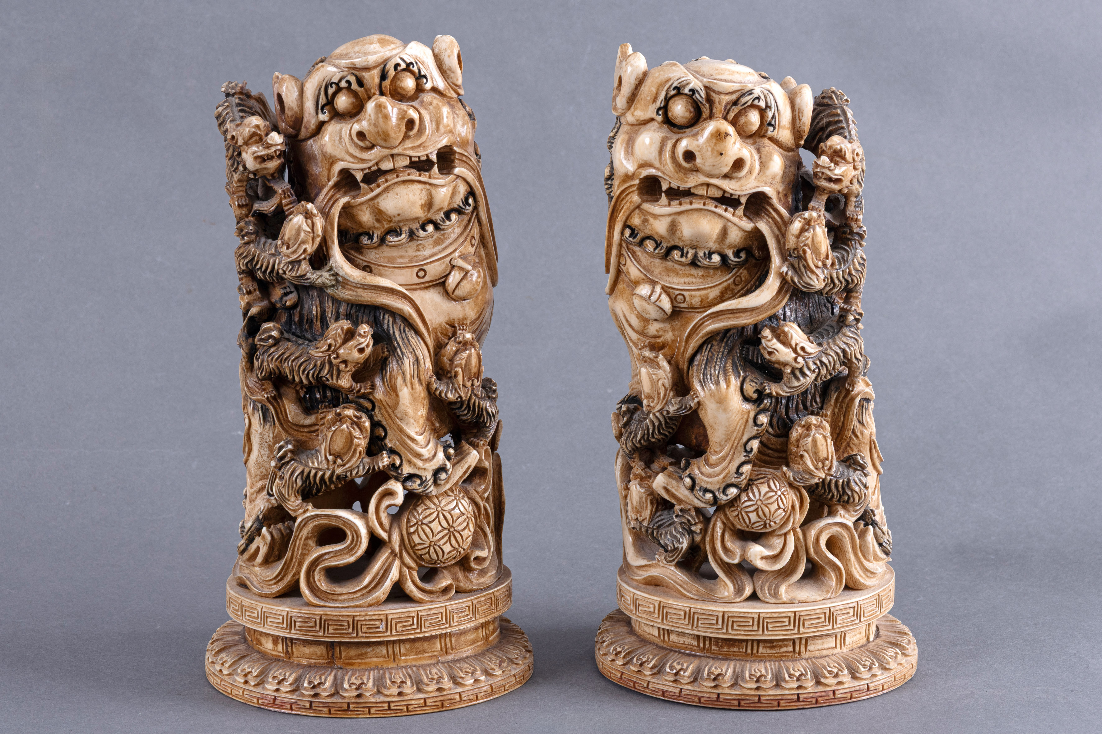 Escuela Cantón (Lingnan) Pp. S.XX. Pareja de leones guardianes con dragones cilíndricos en marfil...