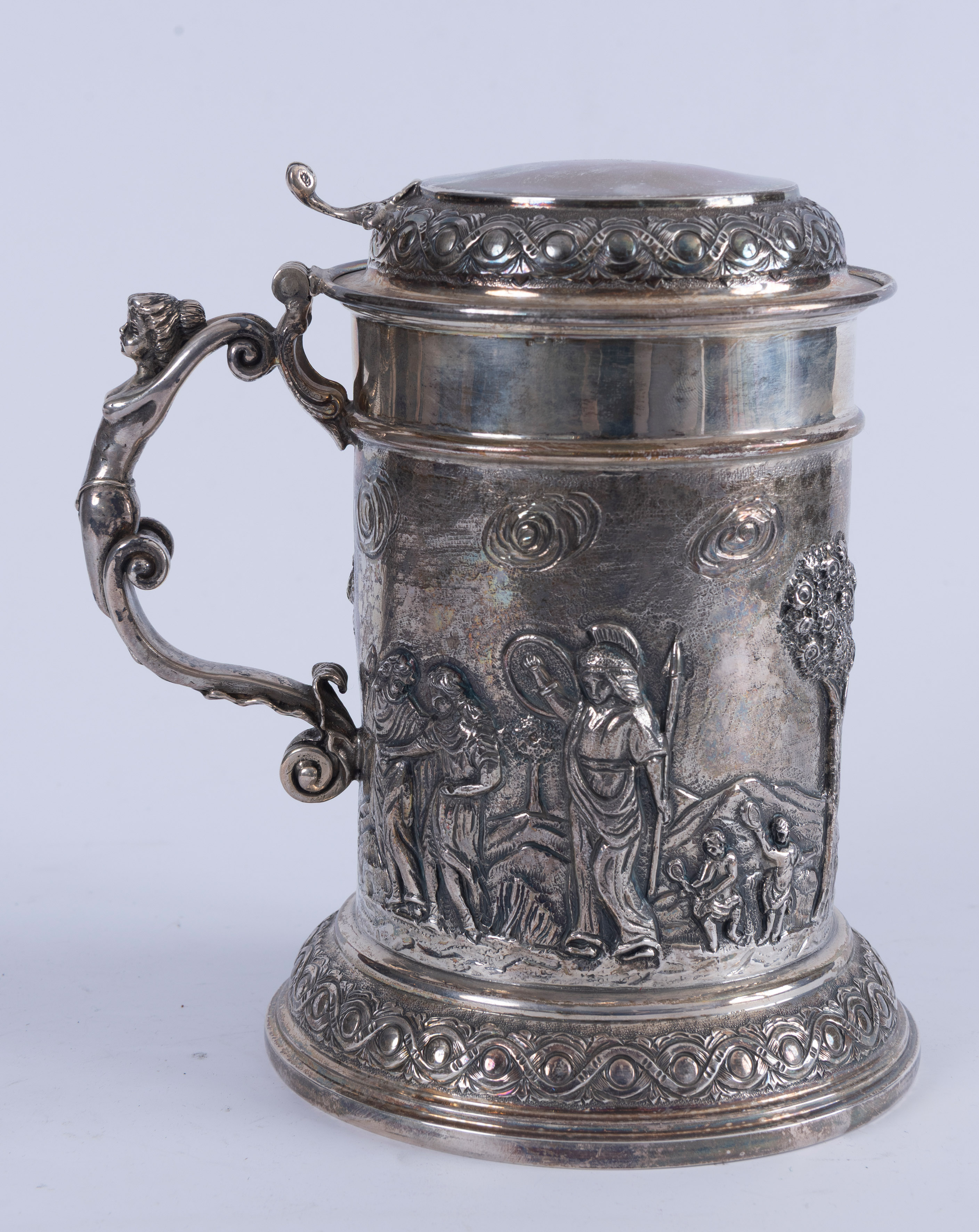 Tankard en plata repujada con escenas de soldados. Mango de ninfa y tapa grabada al igual que la...