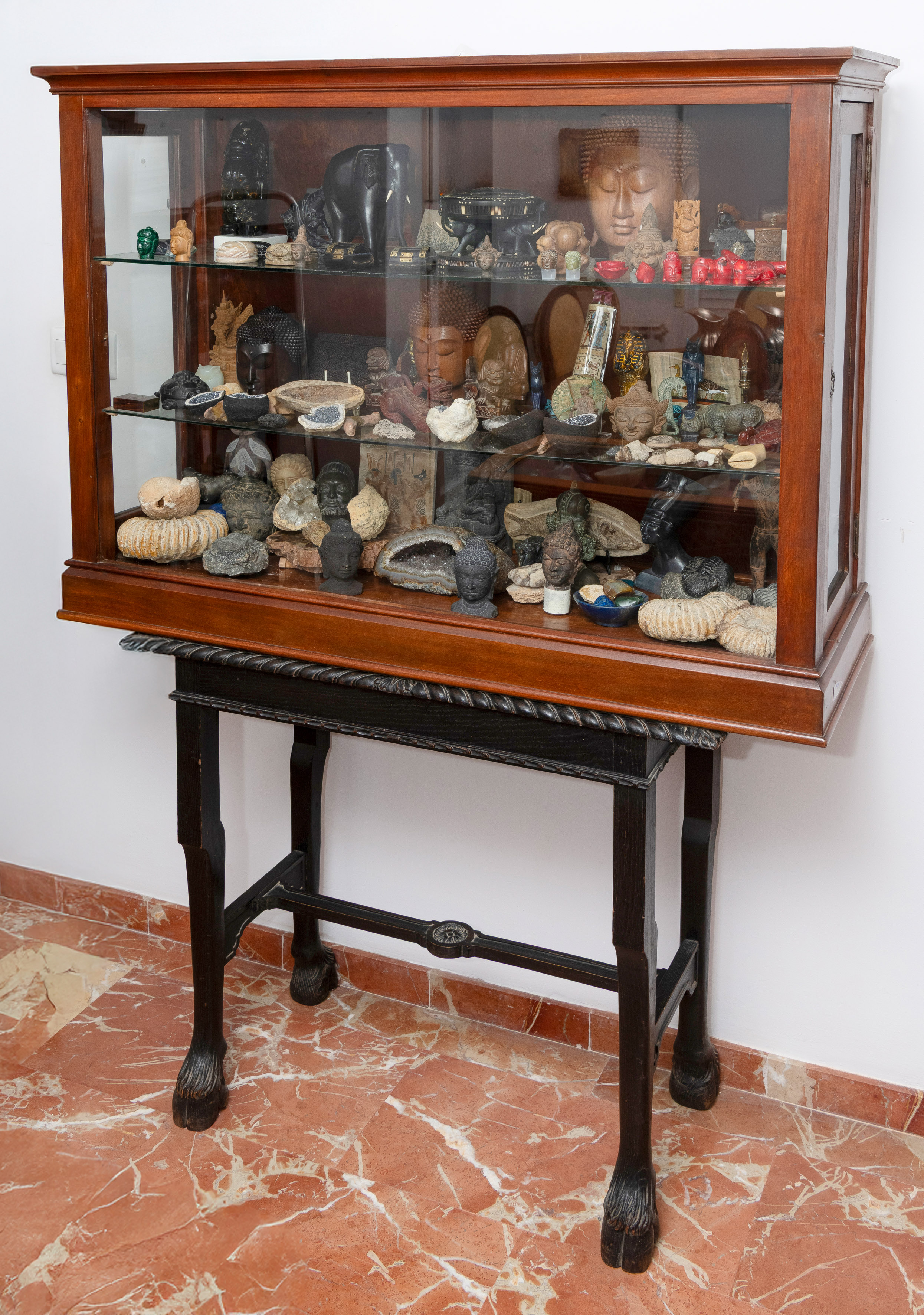 Gran vitrina en madera con colección en su interior de: Cabezas de Buda en diferentes tamaños y...