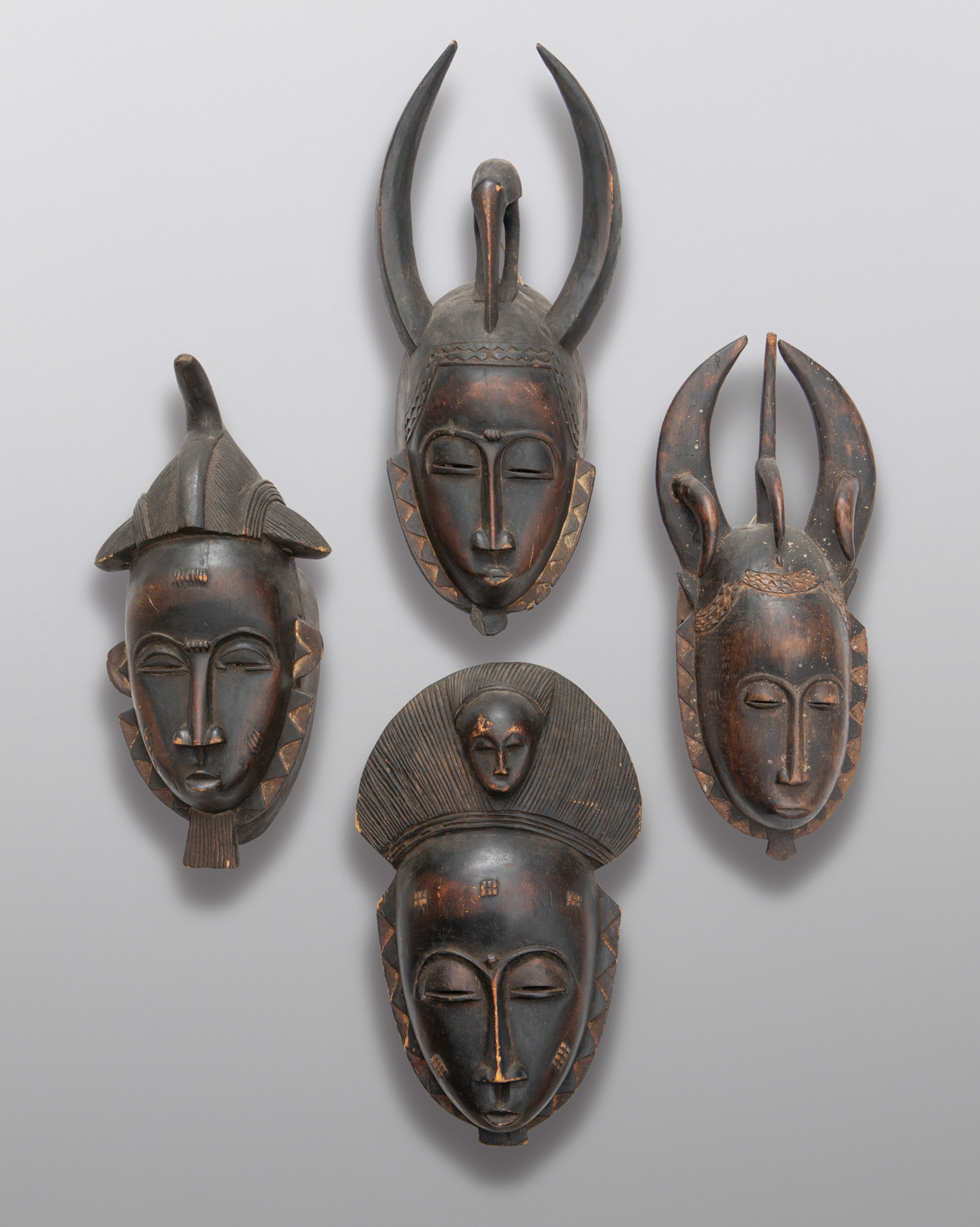 Lote de cuatro máscaras africanas tribales antiguas de Costa de Marfil. 
Dos de ellas con tres...