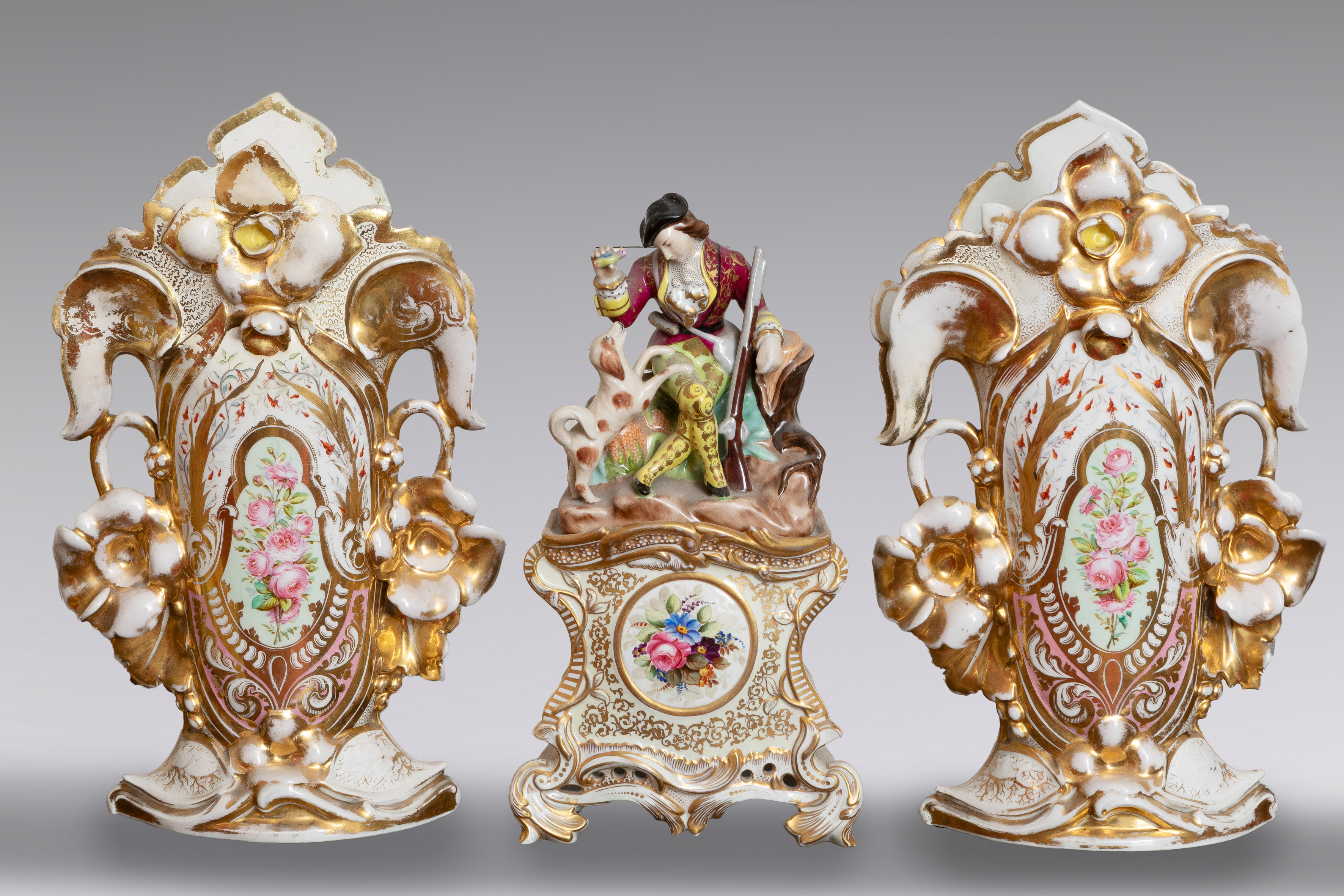 Guarnición isabelina en porcelana blanca con decoración policromada de flores y dorados. 
Compuesta...