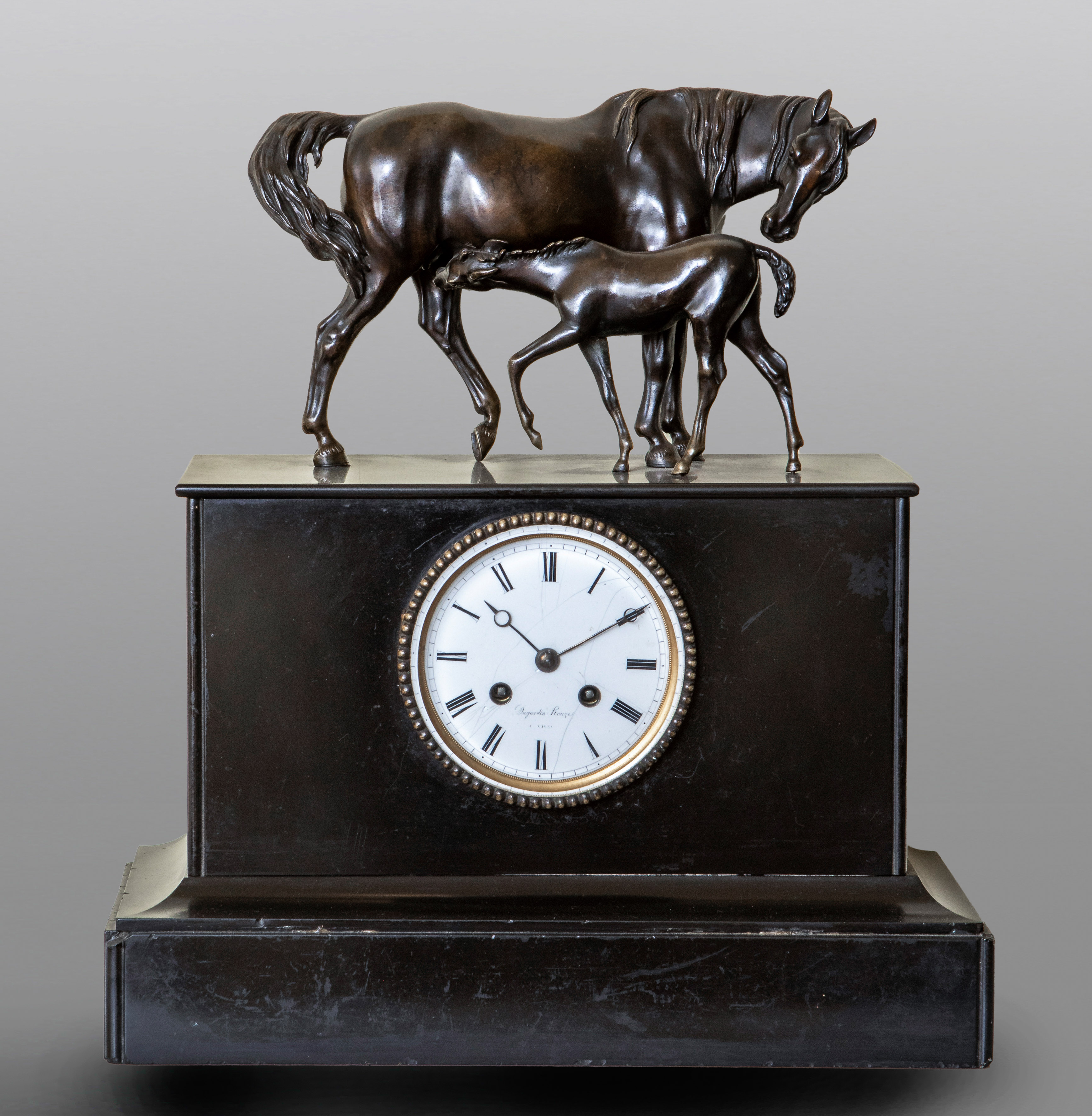 Reloj de sobremesa en bronce pavonado con remate escultórico siguiendo modelos de P.J...