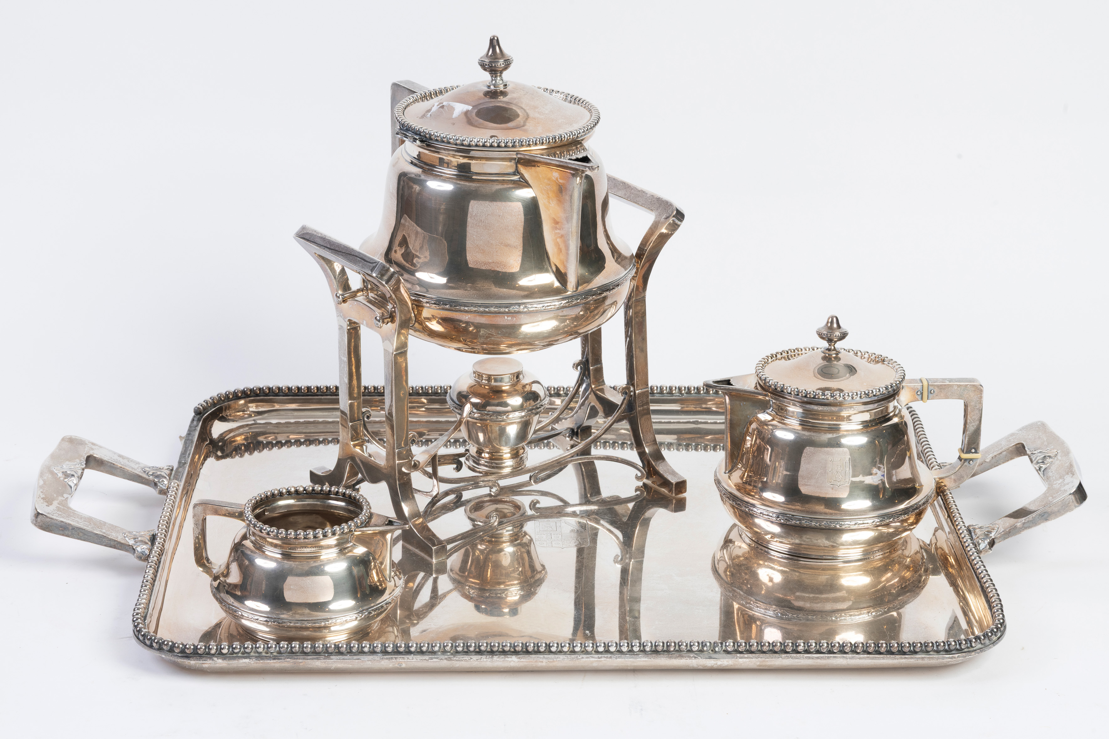 Bandeja, samovar, dos jarras y colador en plata ley 916, con marcas de Luis Sanz, España, S. XX
Con...
