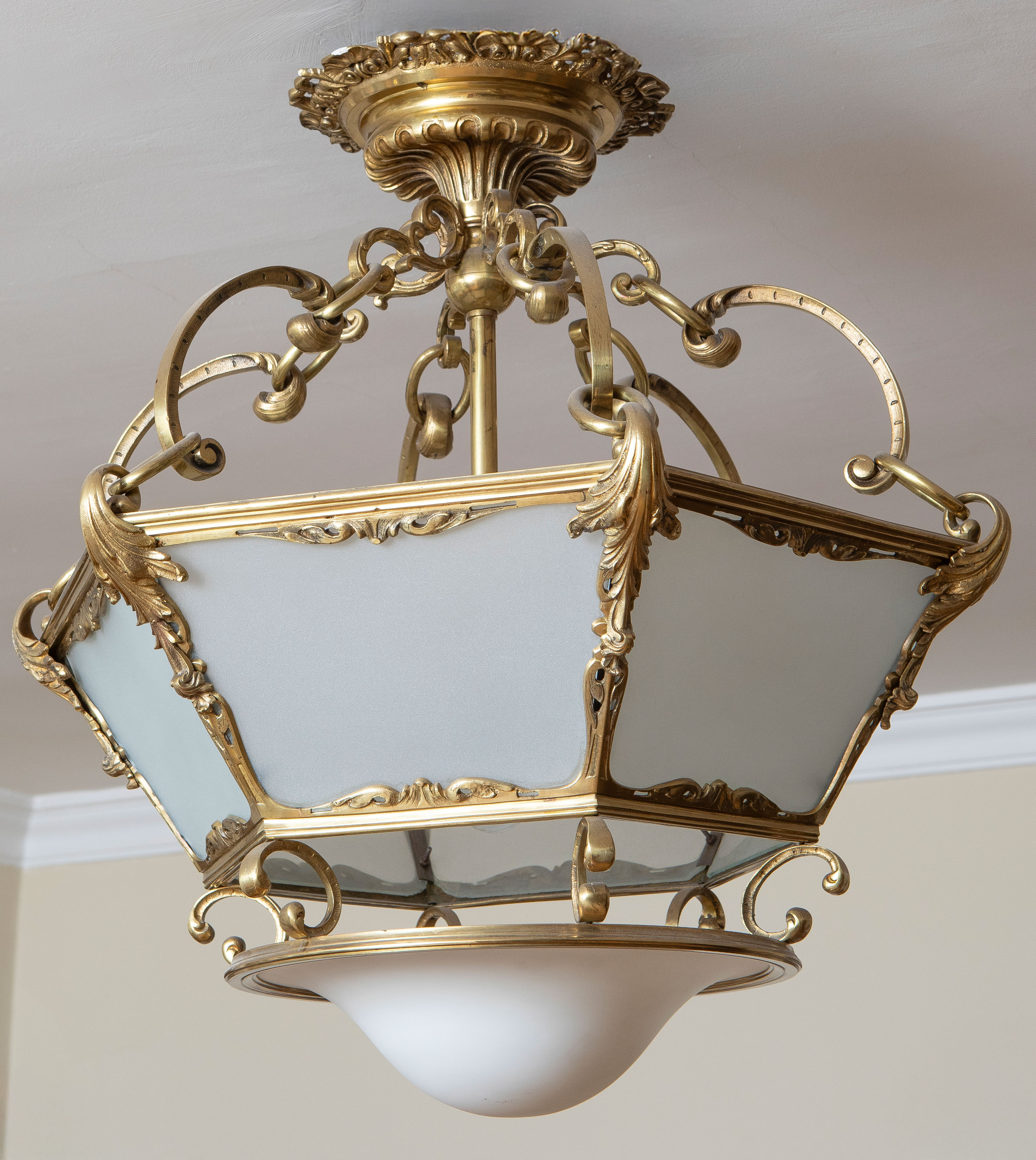 Farol con estructura en broce dorado y paños en cristal esmerilado.
Altura: