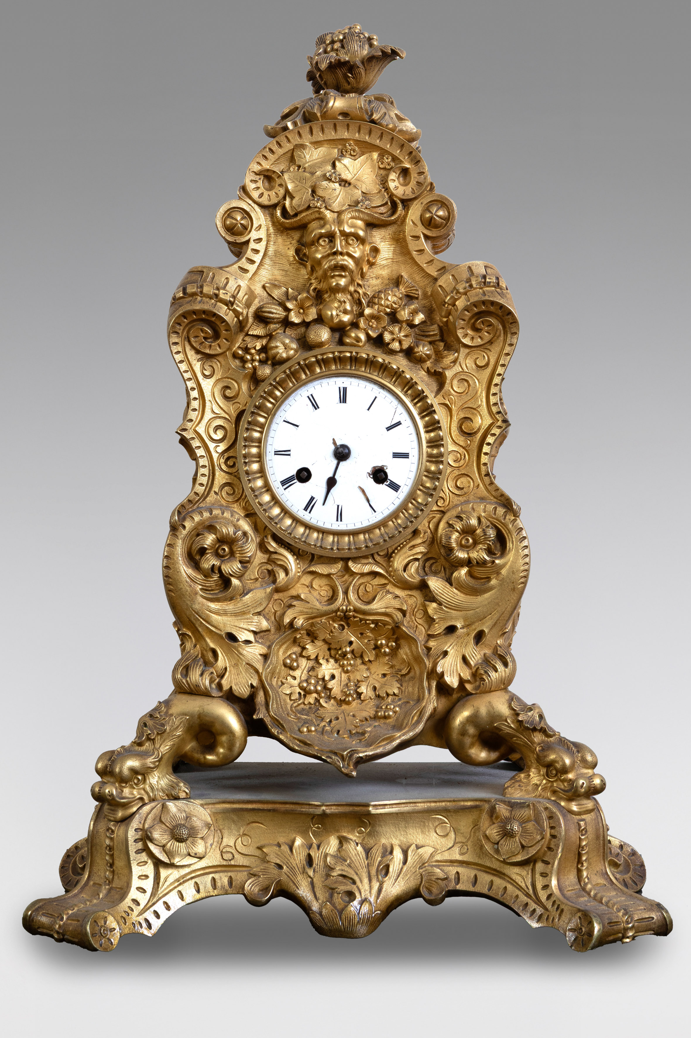 Reloj de sobremesa en bronce dorado. Profusa decoración de flores, palmetas y frutas....