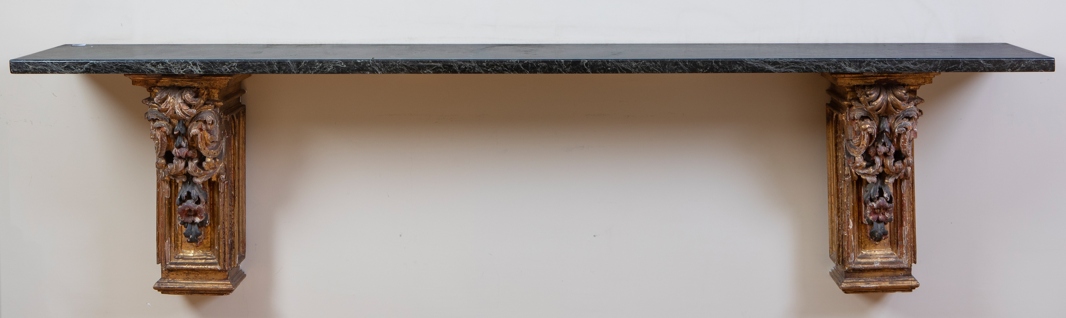 Consola de pared compuesta por pareja de ménsulas barrocas en madera dorada y policromada que...