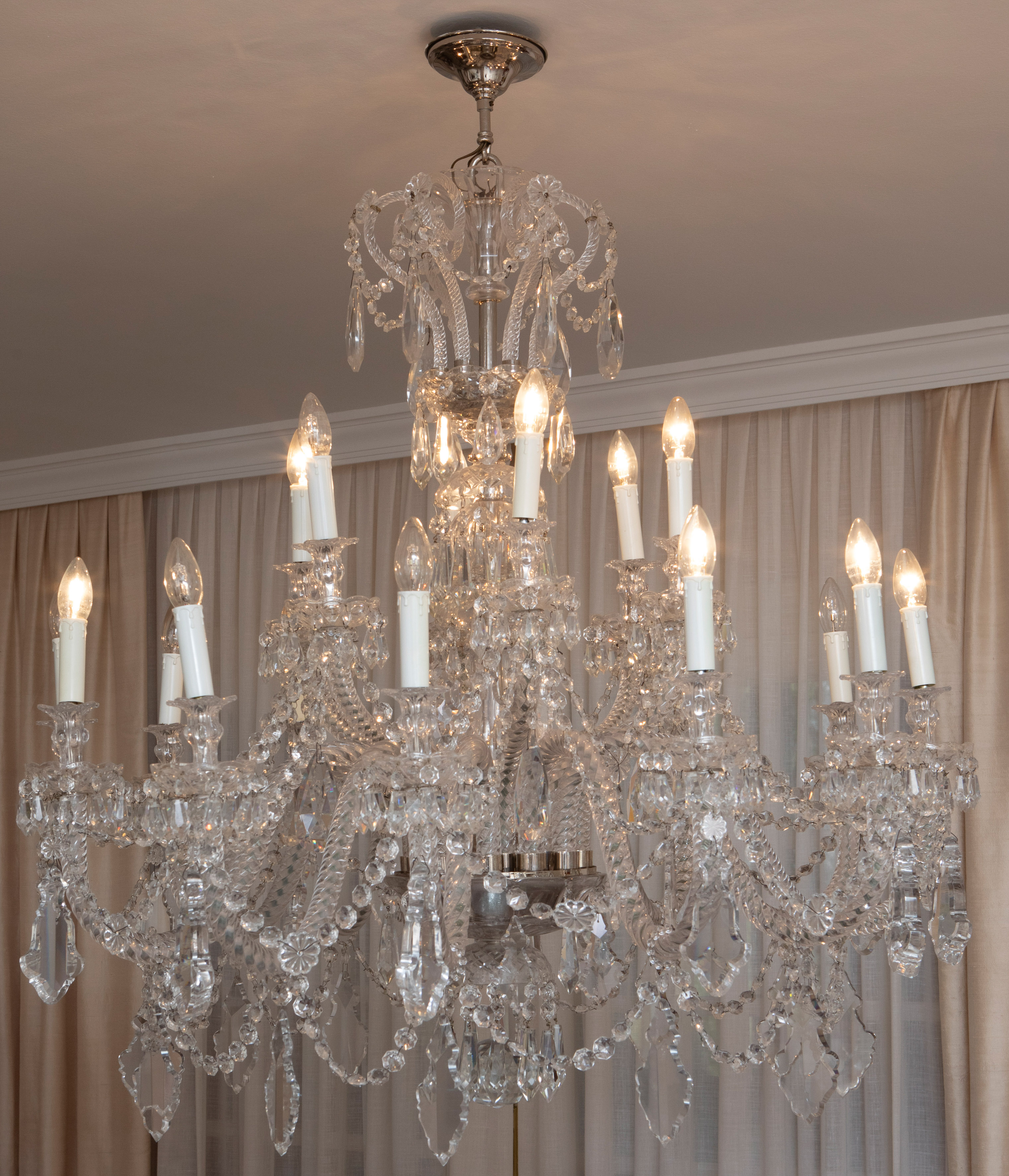 Lámpara de techo con 17 brazos de luz divididos en dos alturas. Con decoración de prismas facetados...