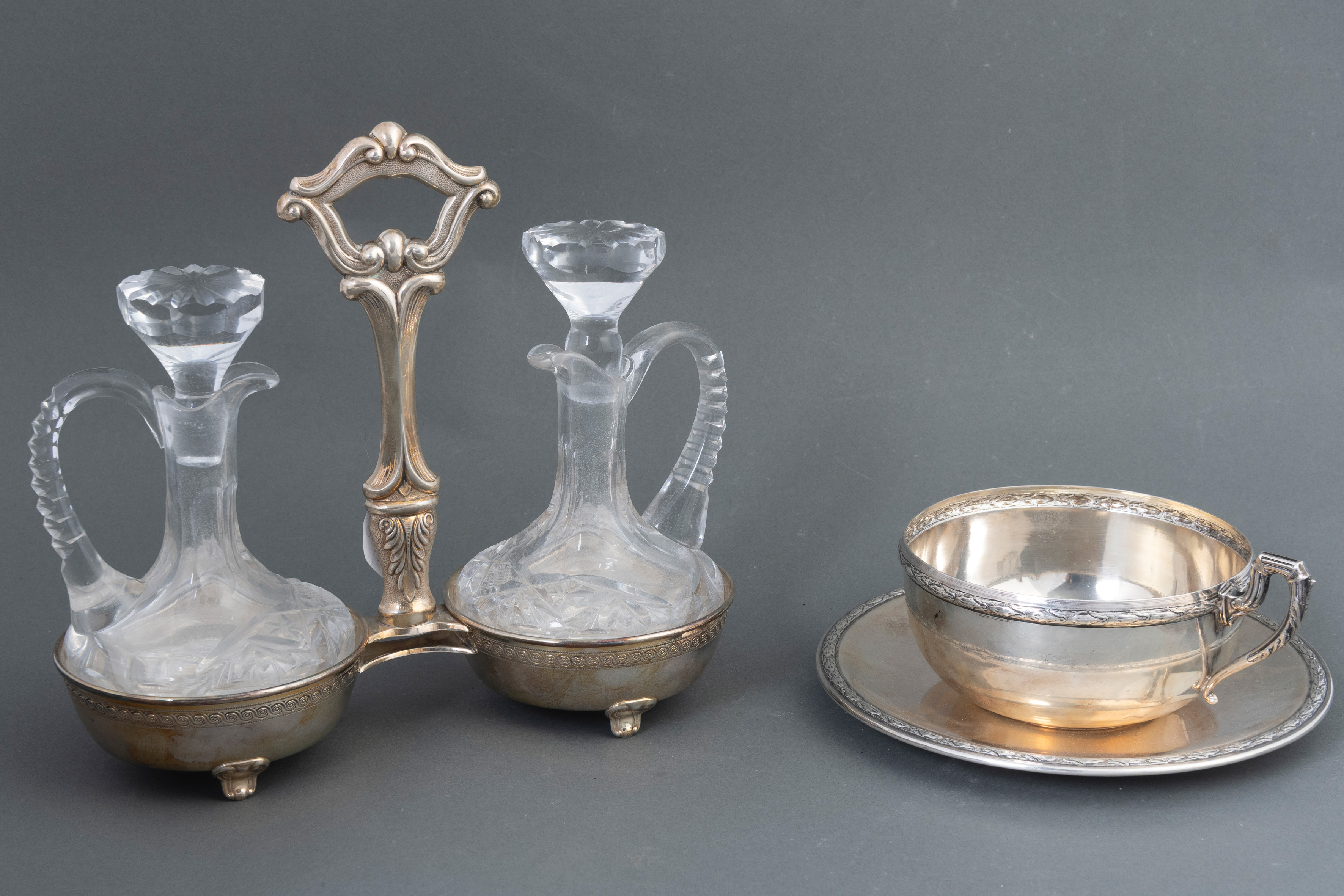 Conjunto de vinajeras en cristal tallado y taza de desayuno con plato con perfiles de laurel. En...