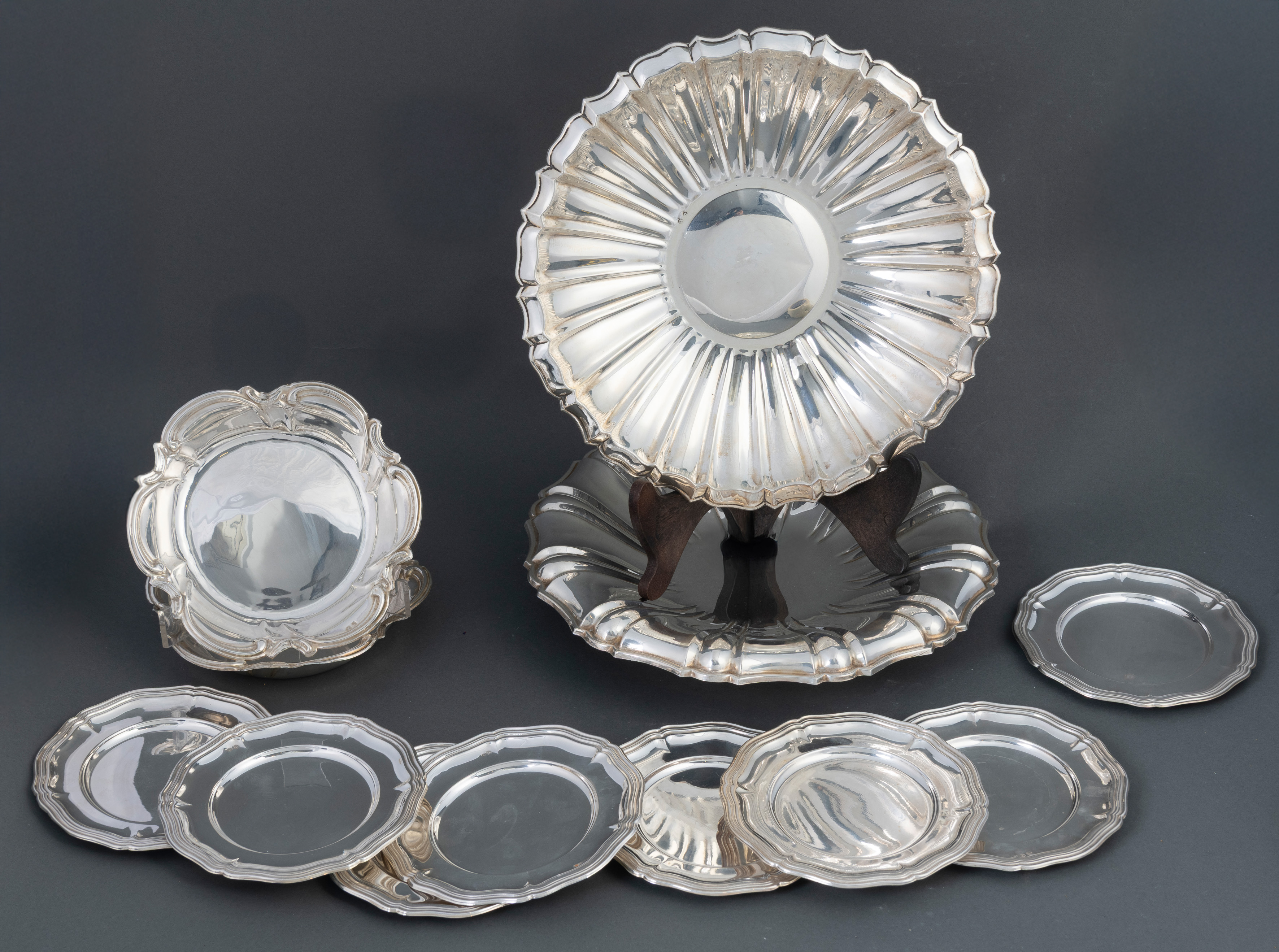 Lote en plata española punzonada. Compuesto por dos paneras gallonadas, dos botelleros con ala de...