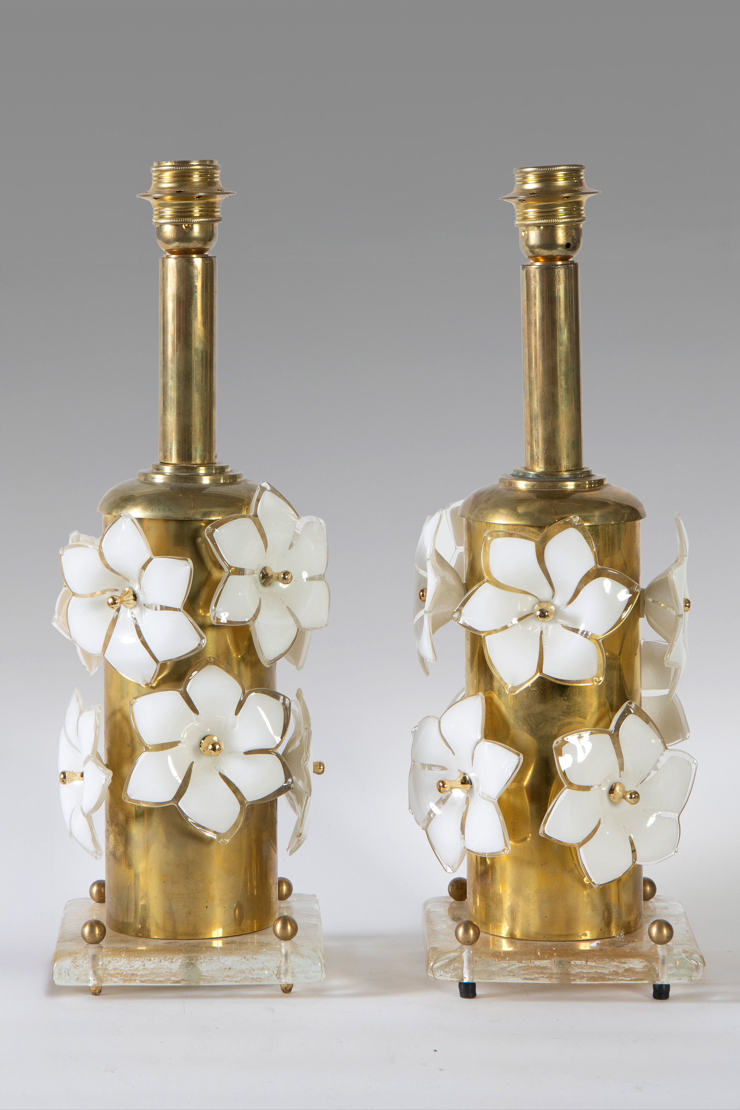 Pareja de lámparas en latón dorado, con base en cristal de Murano y apliques en forma de flores en...