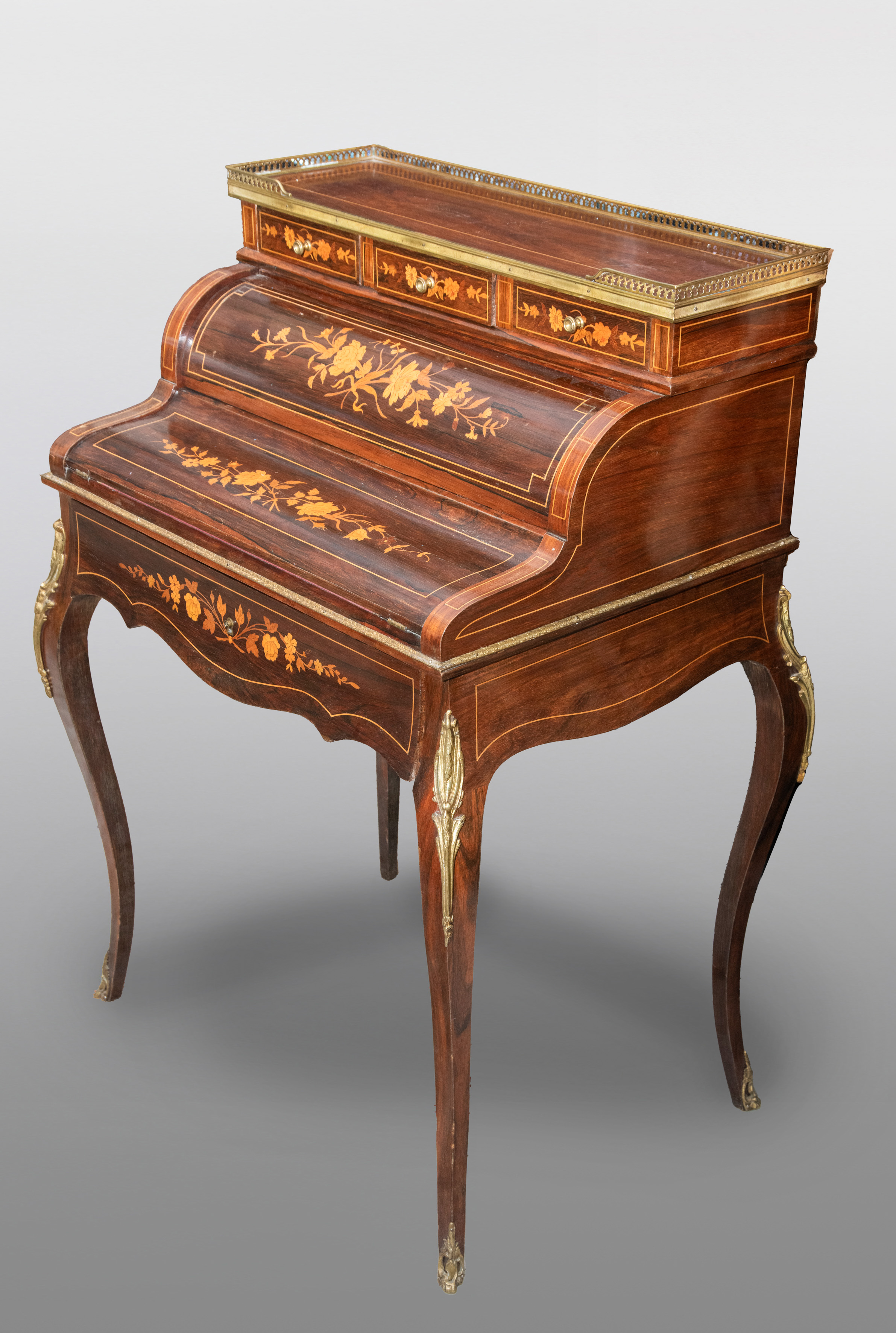 Escritorio estilo Luis XV con marquetería y aplicaciones en bronce dorado.
Medidas: 107 x 73 x 56...