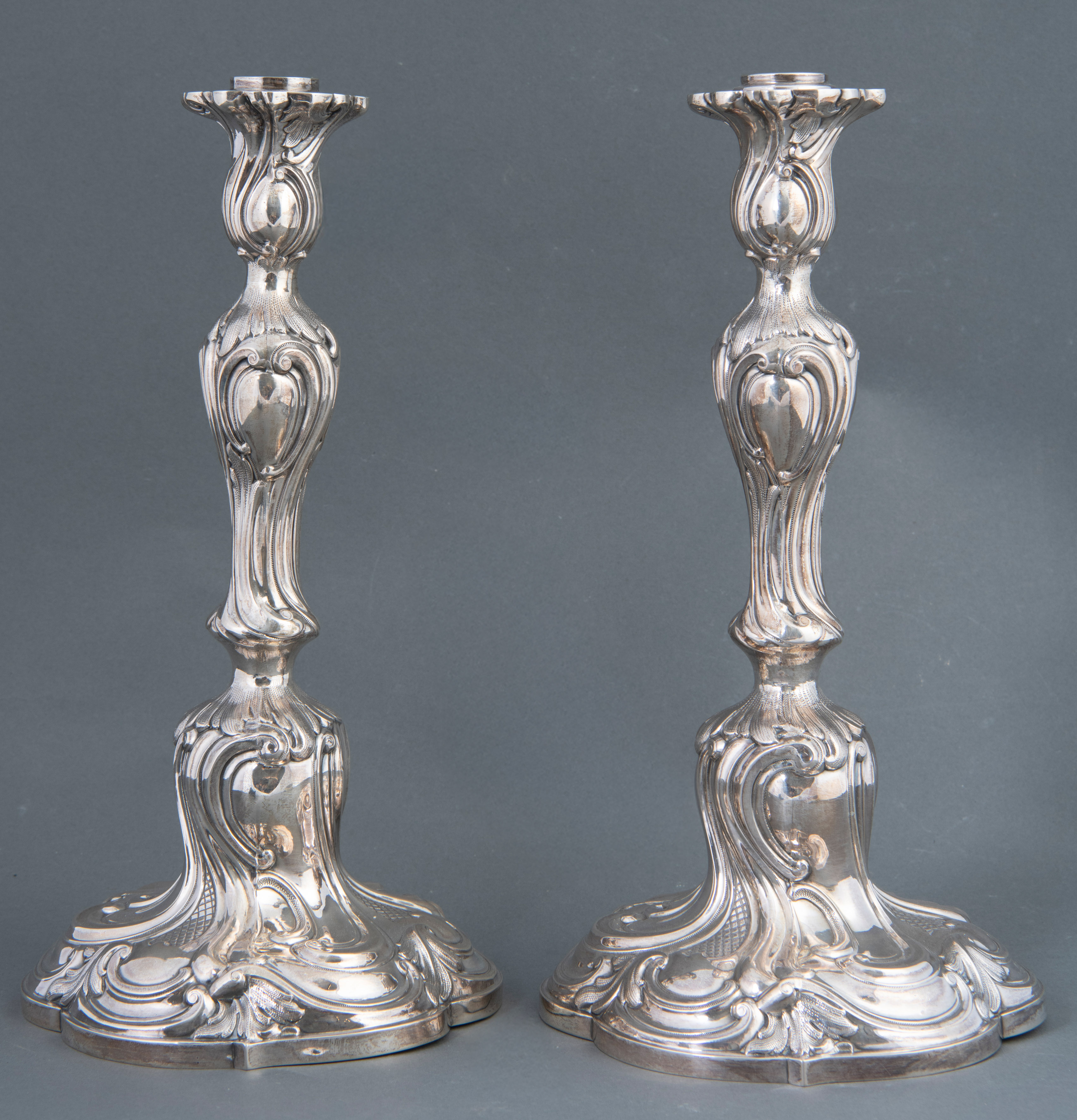 Pareja de candeleros en plata española punzonada; fuste globular repujado con palmetas y...