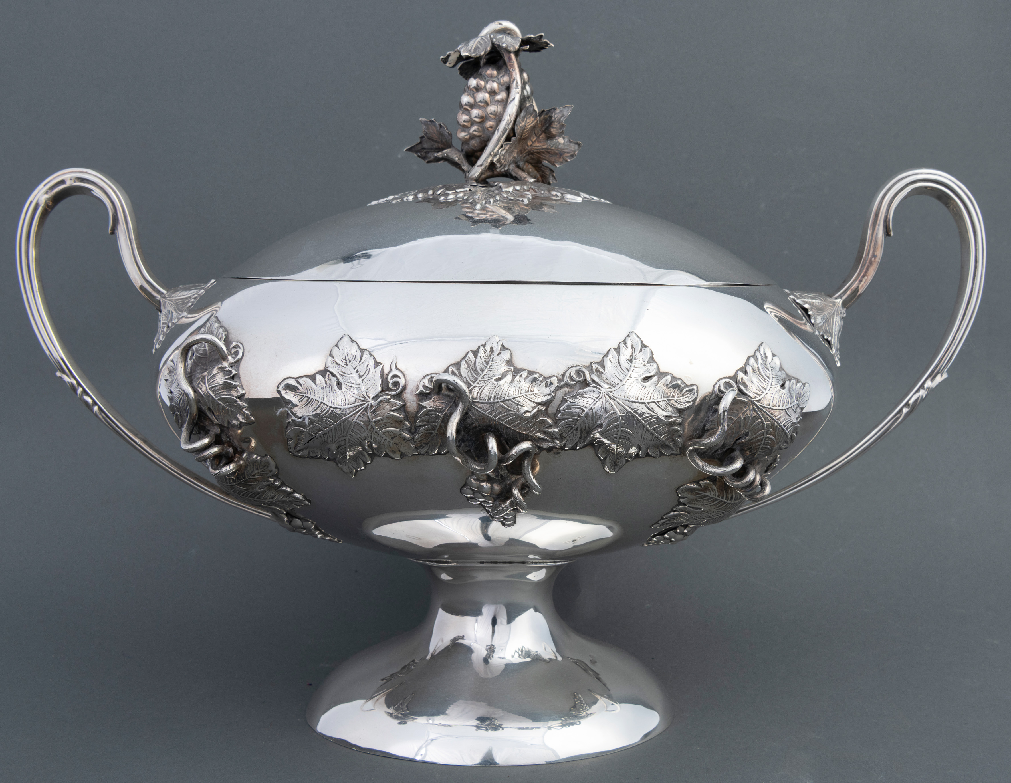 Sopera en plata española punzonada. Original diseño de cuerpo liso con hojas de parra labradas...