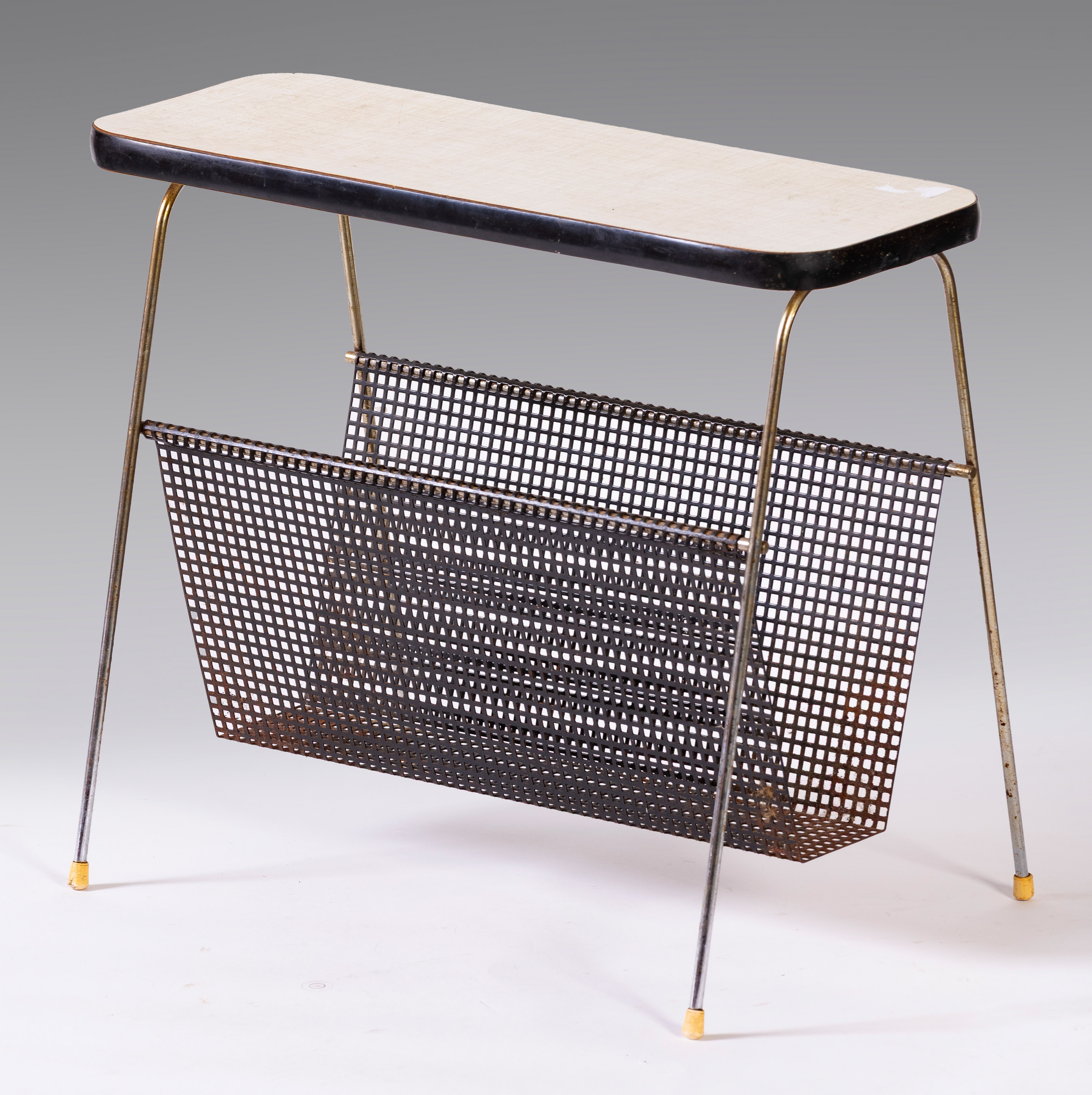 Revistero con bandeja inferior en hierro perforado y tablero de formica. Holanda, hacia 1960...