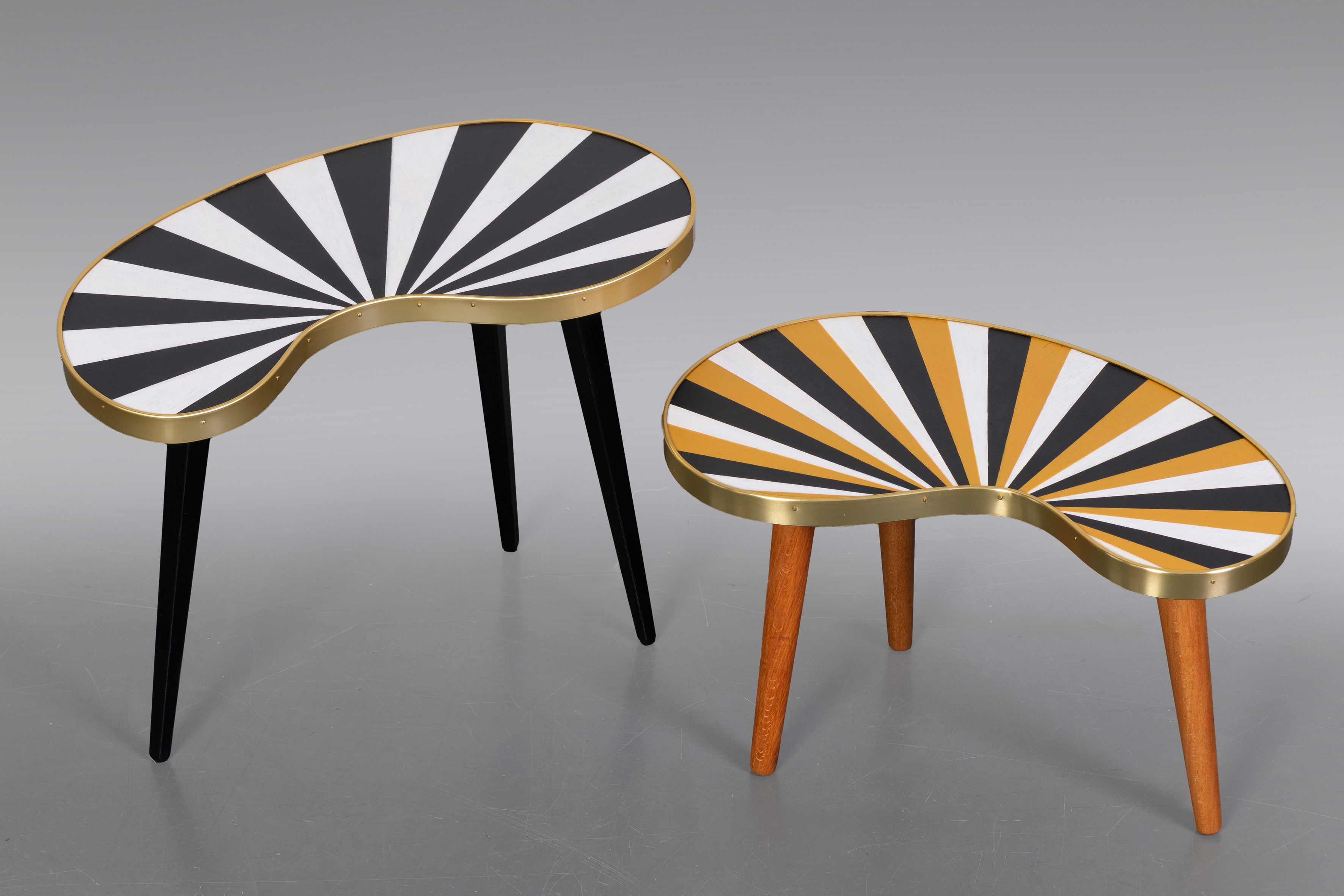 Conjunto formado por dos mesitas en forma de riñón, en madera lacada  y motivos geométricos...