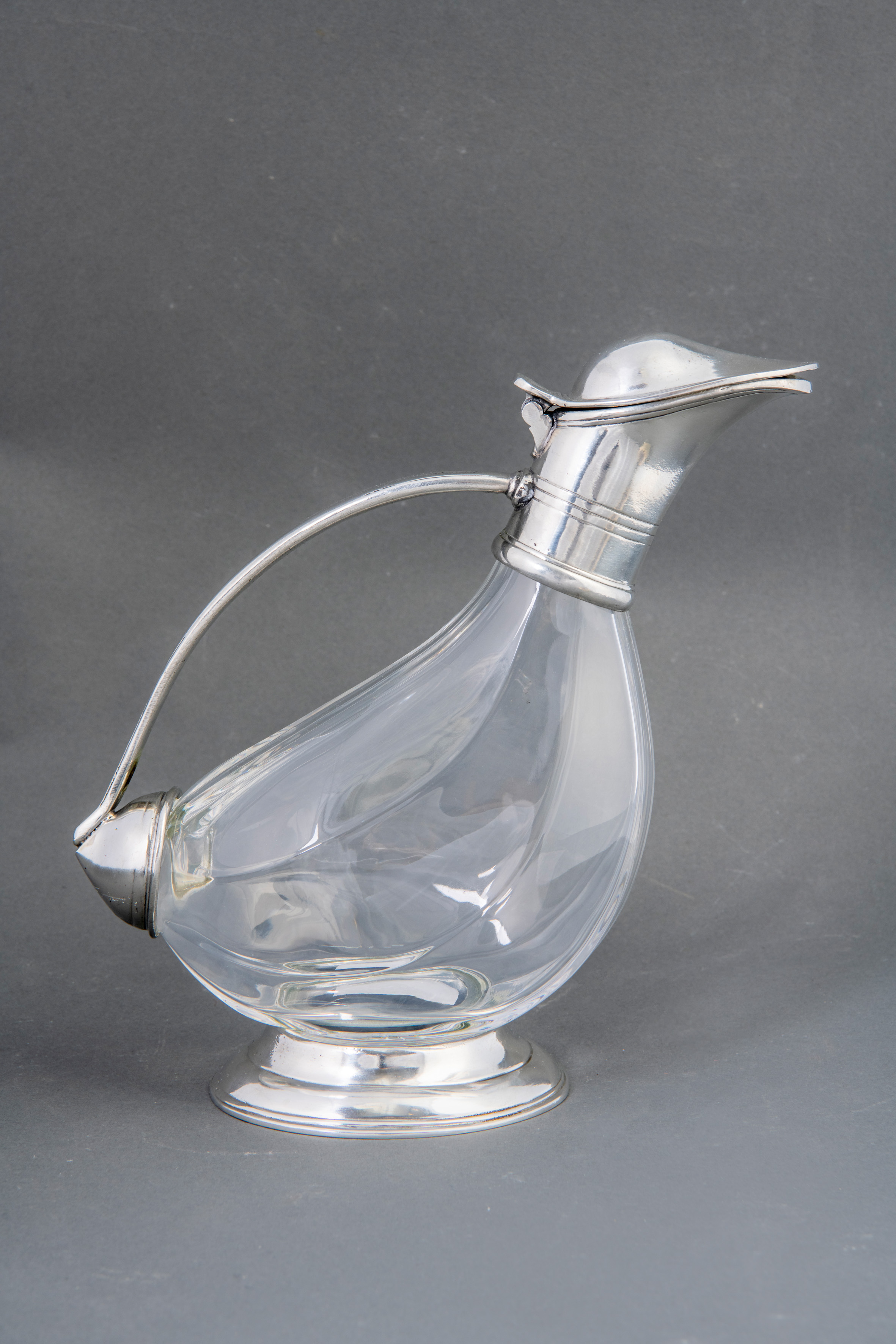 Jarra de vino en cristal tallado con monturas y pico vertedor en plata.
Medidas: 23 x 26 cm.