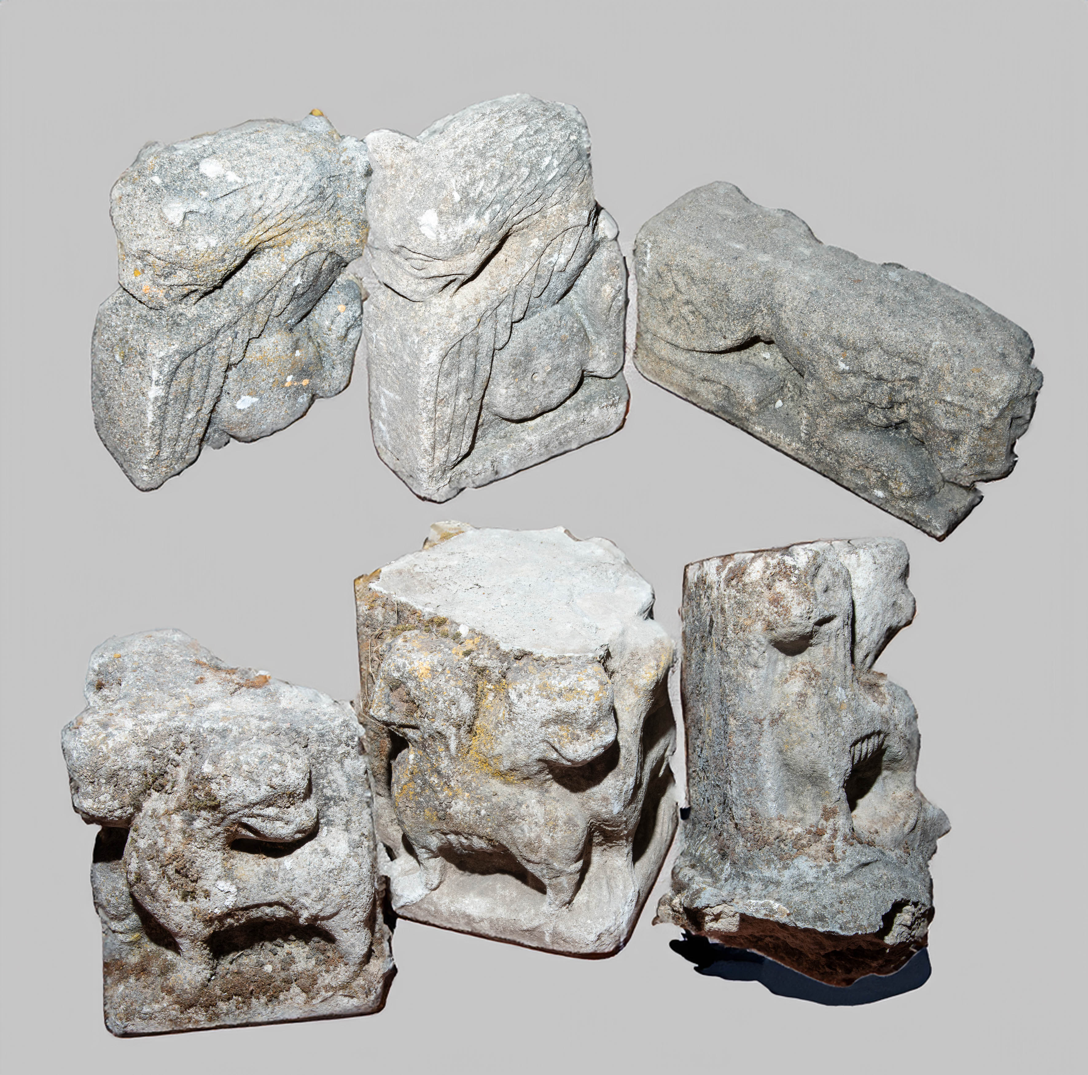 Lote de tres ménsulas y tres capiteles con decoración zoomórfica de leones guardianes en piedra...