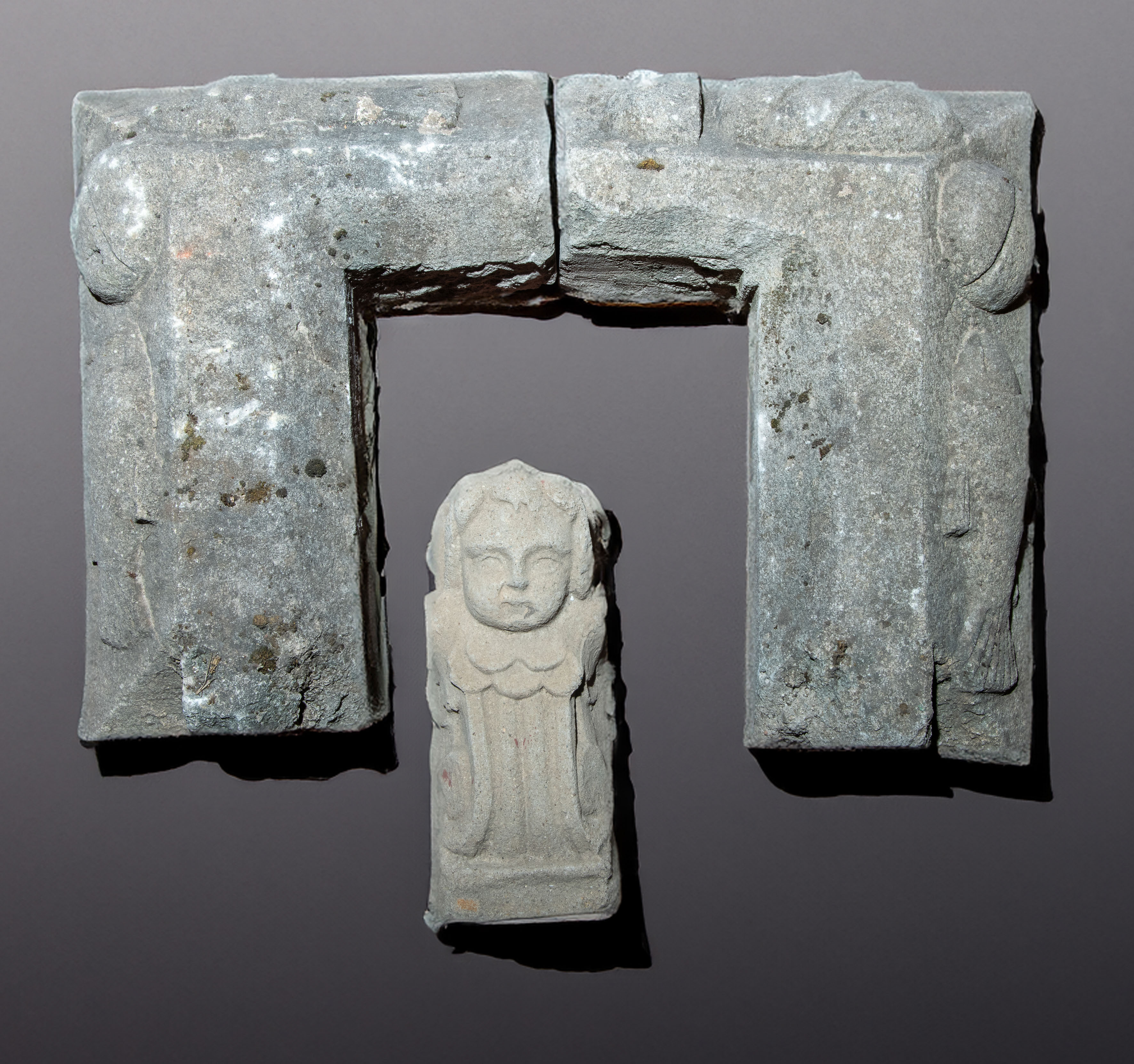 Parte de un friso con relieve del milagro de los panes y los peces y ménsula de angelito en piedra...