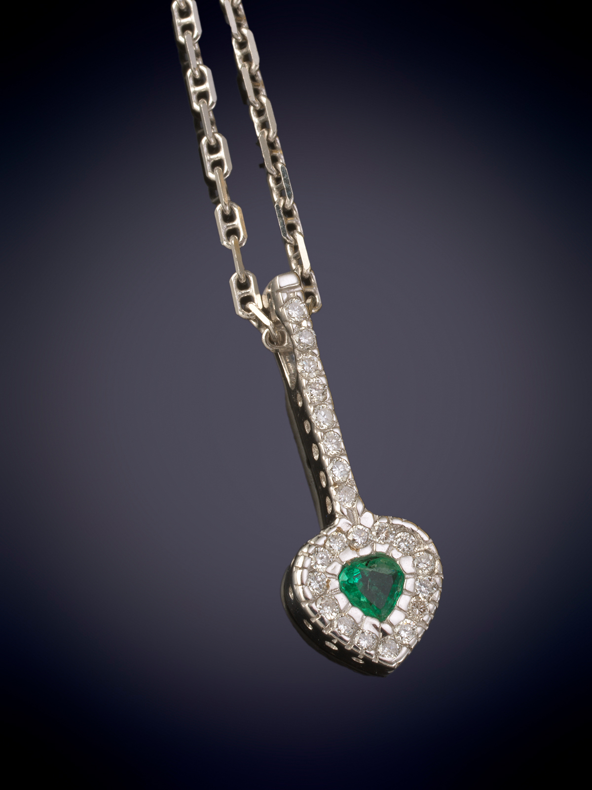 COLGANTE DE BRILLANTES Y ESMERALDA CENTRAL, TALLA CORAZÓN, QUE PENDE DE BARRA DE BRILLANTES, Y...