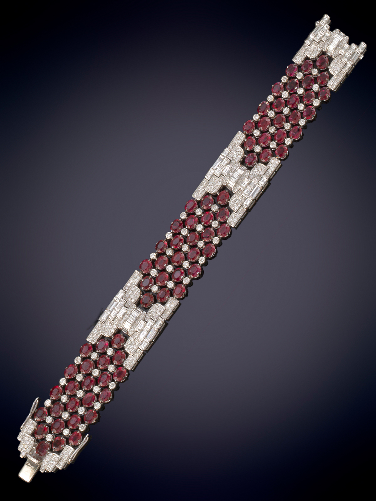 ELEGANTE BRAZALETE DE BRILLANTES, DIAMANTES EN BAGUETTE Y BELLOS RUBÍES TALLA OVAL EN MOTIVOS...