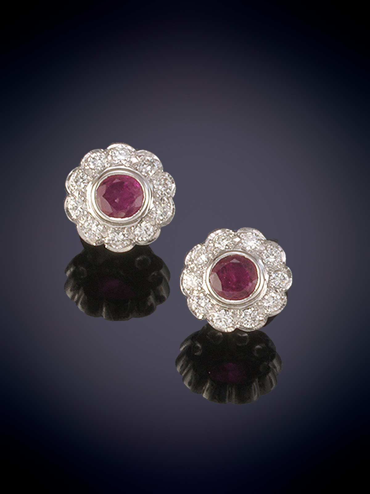 PENDIENTES ROSETON DE BRILLANTES CON CENTRO DE RUBI, TALLA OVAL. Sobre una montura de oro blanco de...