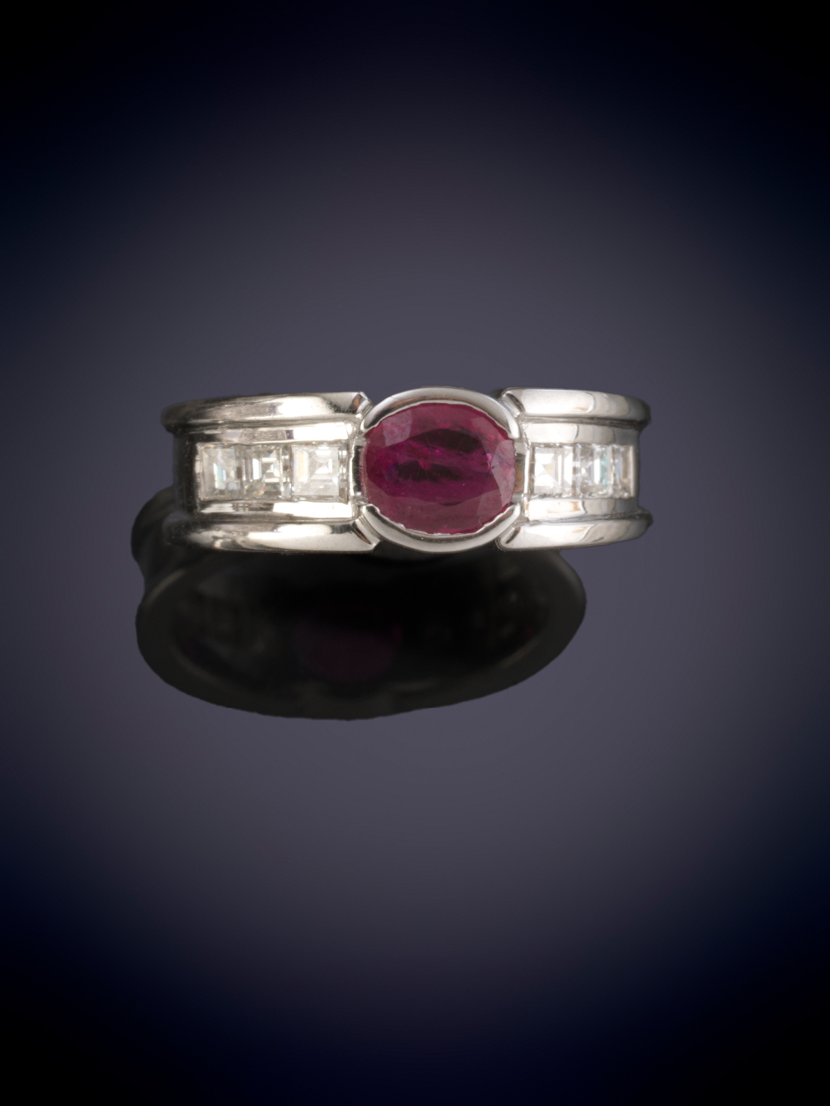 SORTIJA CON UN RUBI TALLA OVAL FLANQUEADA POR DIAMANTES TALLA CARRE DE GRAN CALIDAD sobre una...