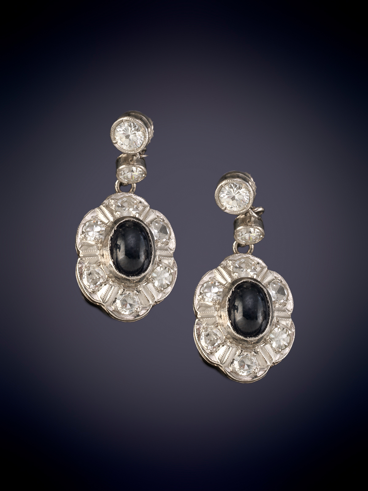 PENDIENTES CON CAIDA DE ZAFIRO EN CABUJÓN ORLADOS POR DIAMANTES. Montura en platino.