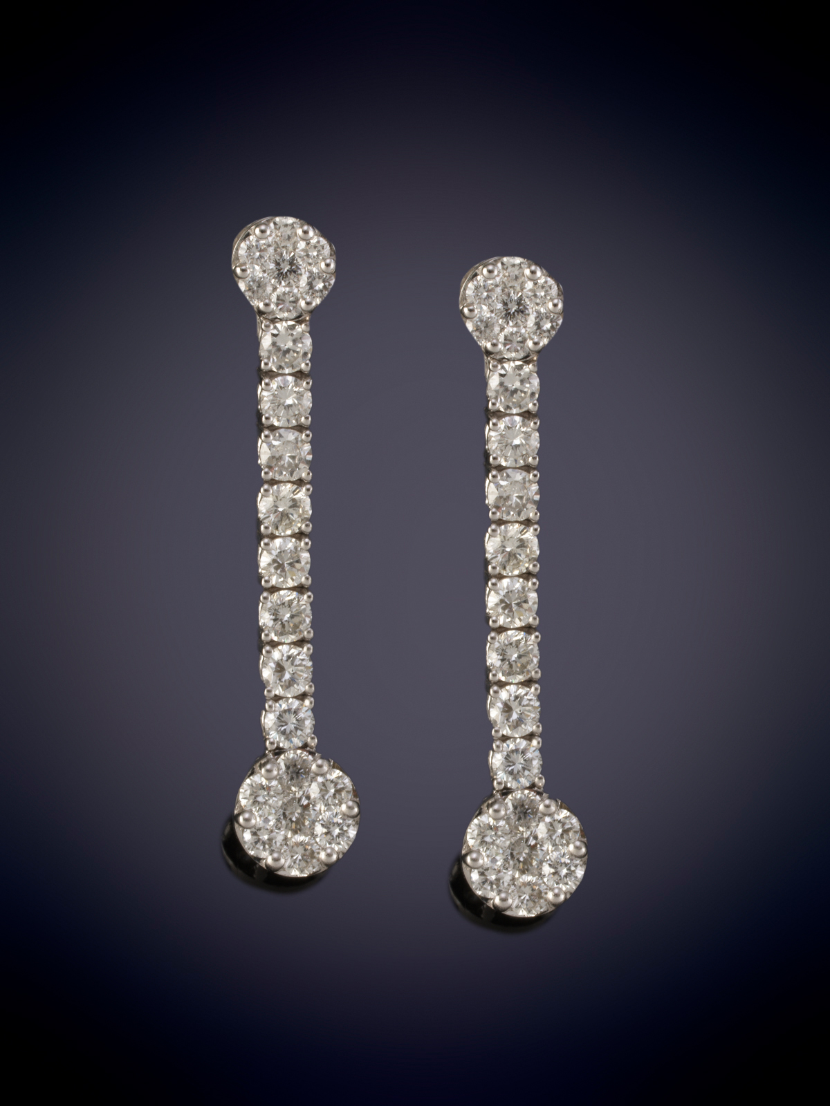 PENDIENTES LARGOS CON HILERA Y ROSETONES DE BRILLANTES. Montura en oro blanco de 18k.