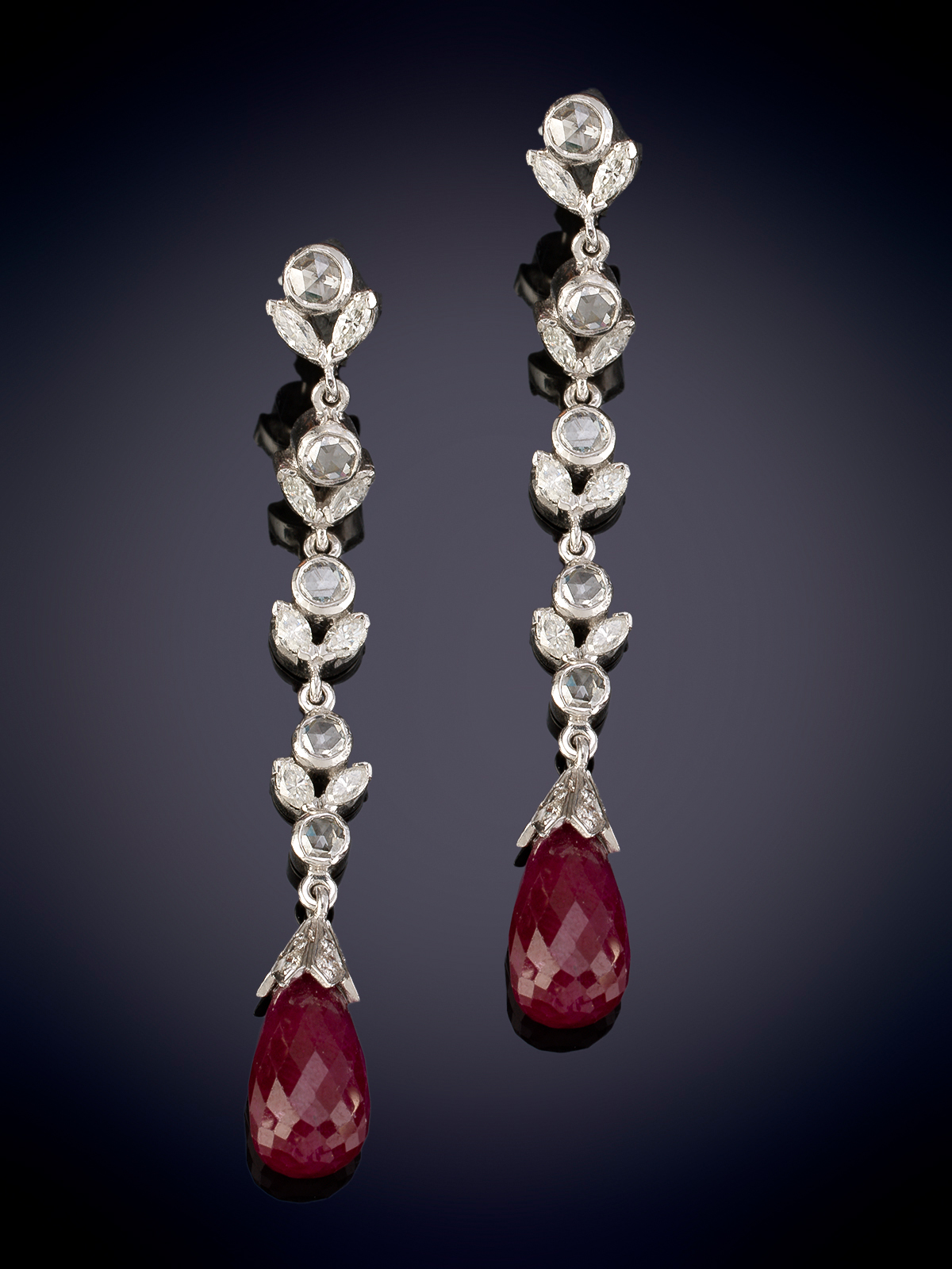 Penientes largos de diamantes en forma de guirnalda, que sujetan pareja  de cabujones de rubíes...