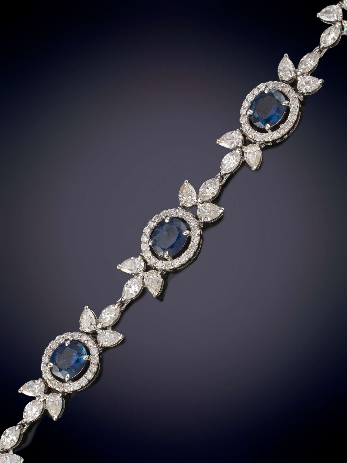 PULSERA FLEXIBLE DE ESLABONES, FORMADA POR OCHO ZAFIROS TALLA OVAL CON UN PESO DE 6.25 CTS. ORLADOS...