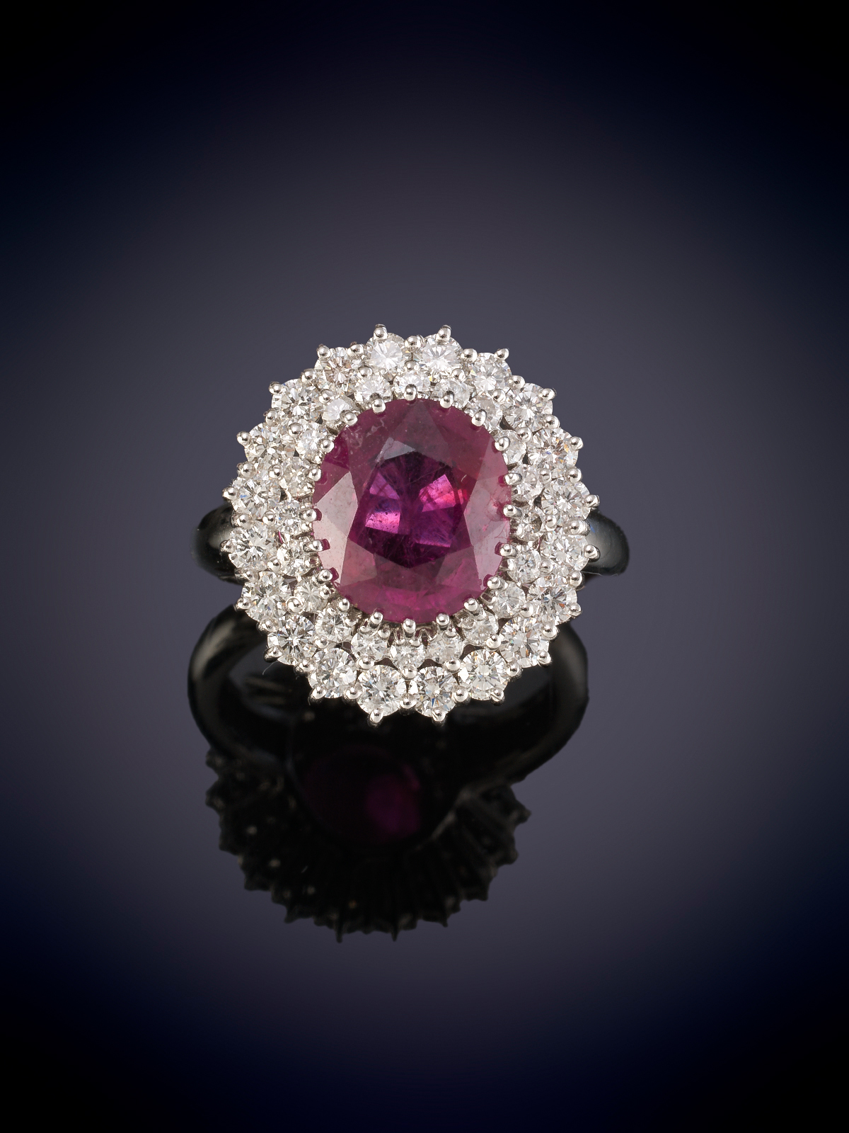 Sortija rubí talla oval de intenso color de 3.71 ct . Doble orla de brillantes con un  peso total...