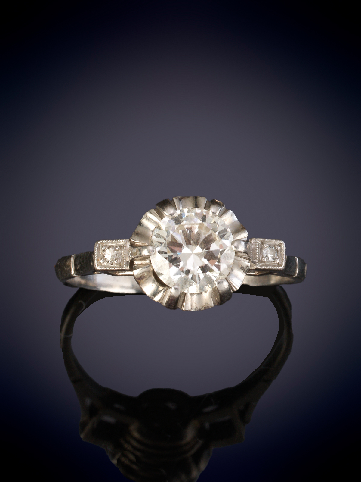 SOLITARIO ANTIGUO CON BRILLANTE DE 0,50 CT. APROX sobre fina montura de garras flanqueado por...