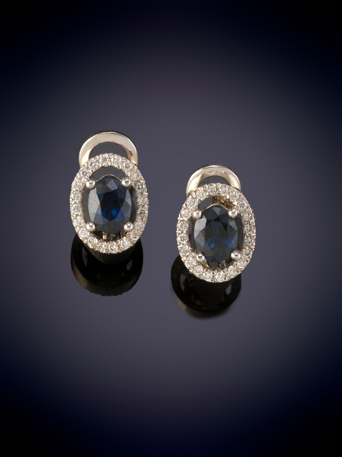 ELEGANTES PENDIENTES DE ZAFIROS TALLA OVAL CON UN PESO DE 1,87 cts. CON ORLA CIRCULAR DE BRILLANTES...