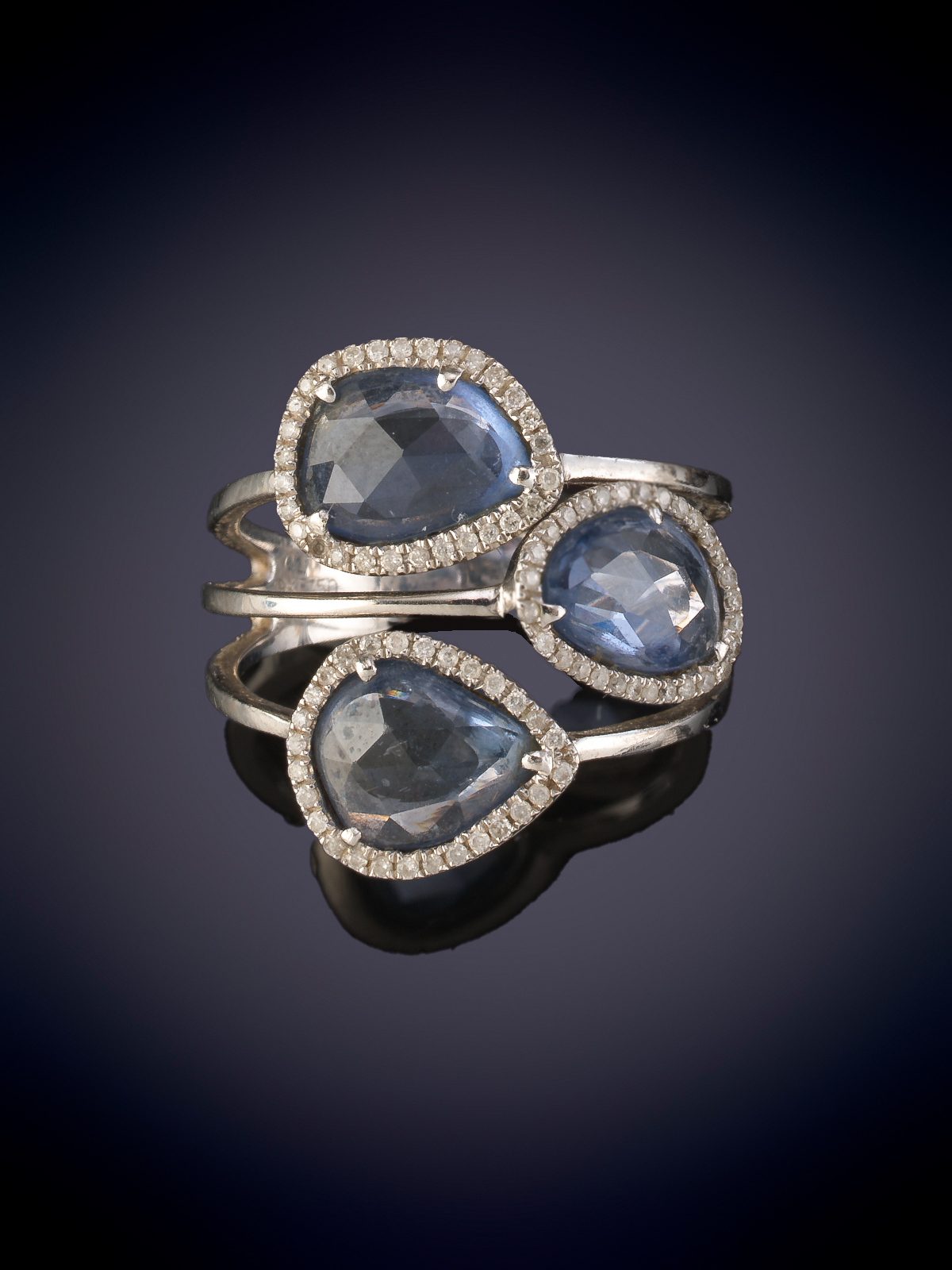 MODERNA SORTIJA COMPUESTA POR TRES CUARZOS AZULES RODEADOS DE BRILLANTES. Montura en oro blanco de...