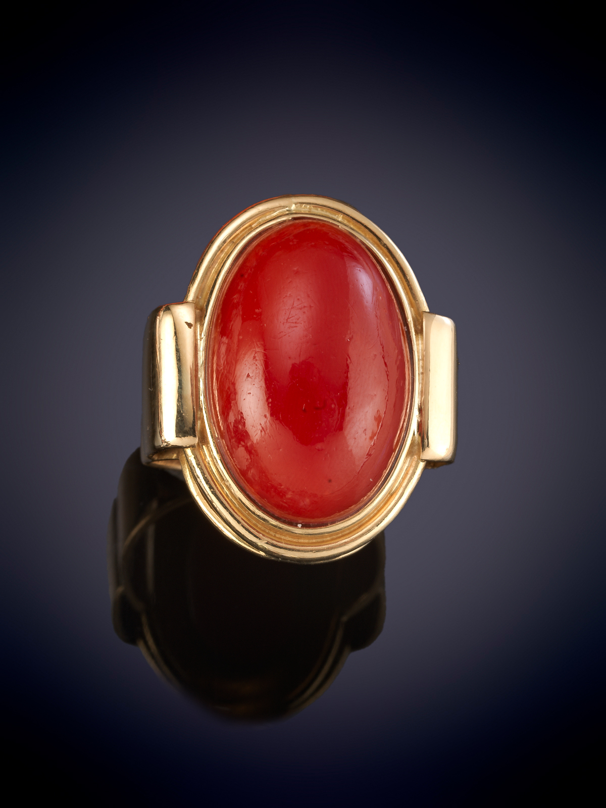 GRAN SORTIJA MODERNA OVAL CON CABUJON DE CORAL ROJO MEDITERRÁNEO. Montura en oro amarillo de 18k.